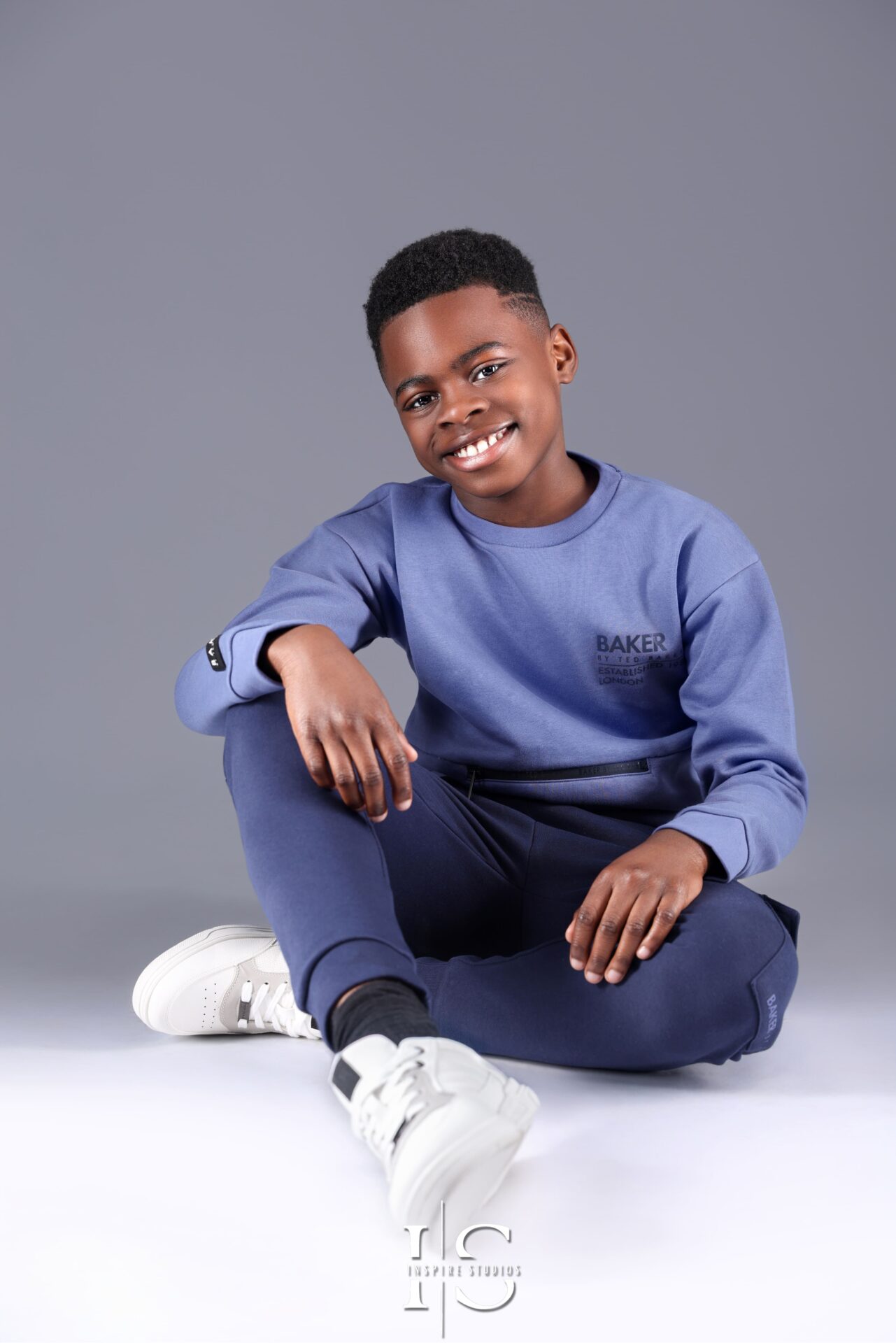 Young boy posing during a 10-year milestone studio photoshoot.