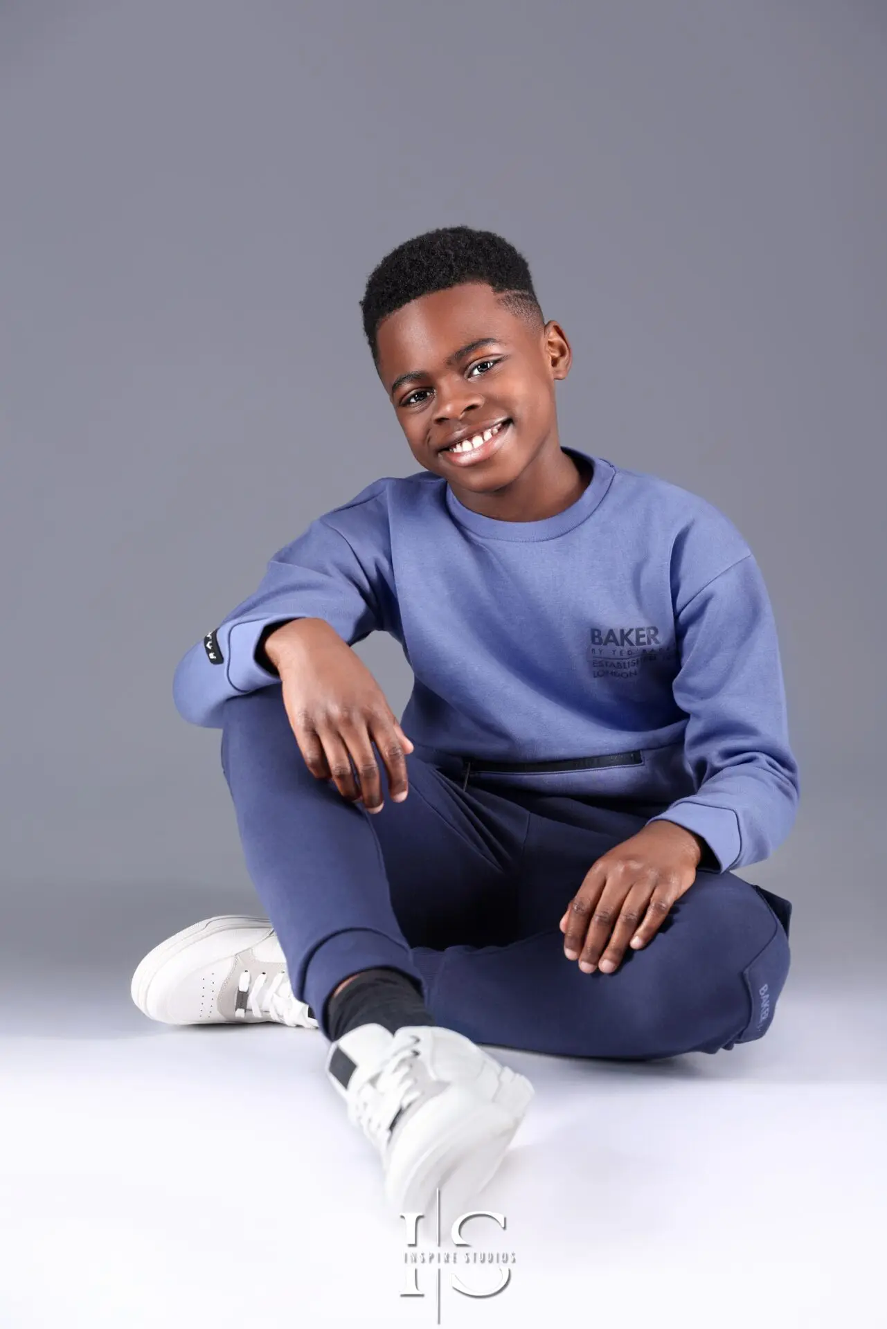 Young boy posing during a 10-year milestone studio photoshoot.