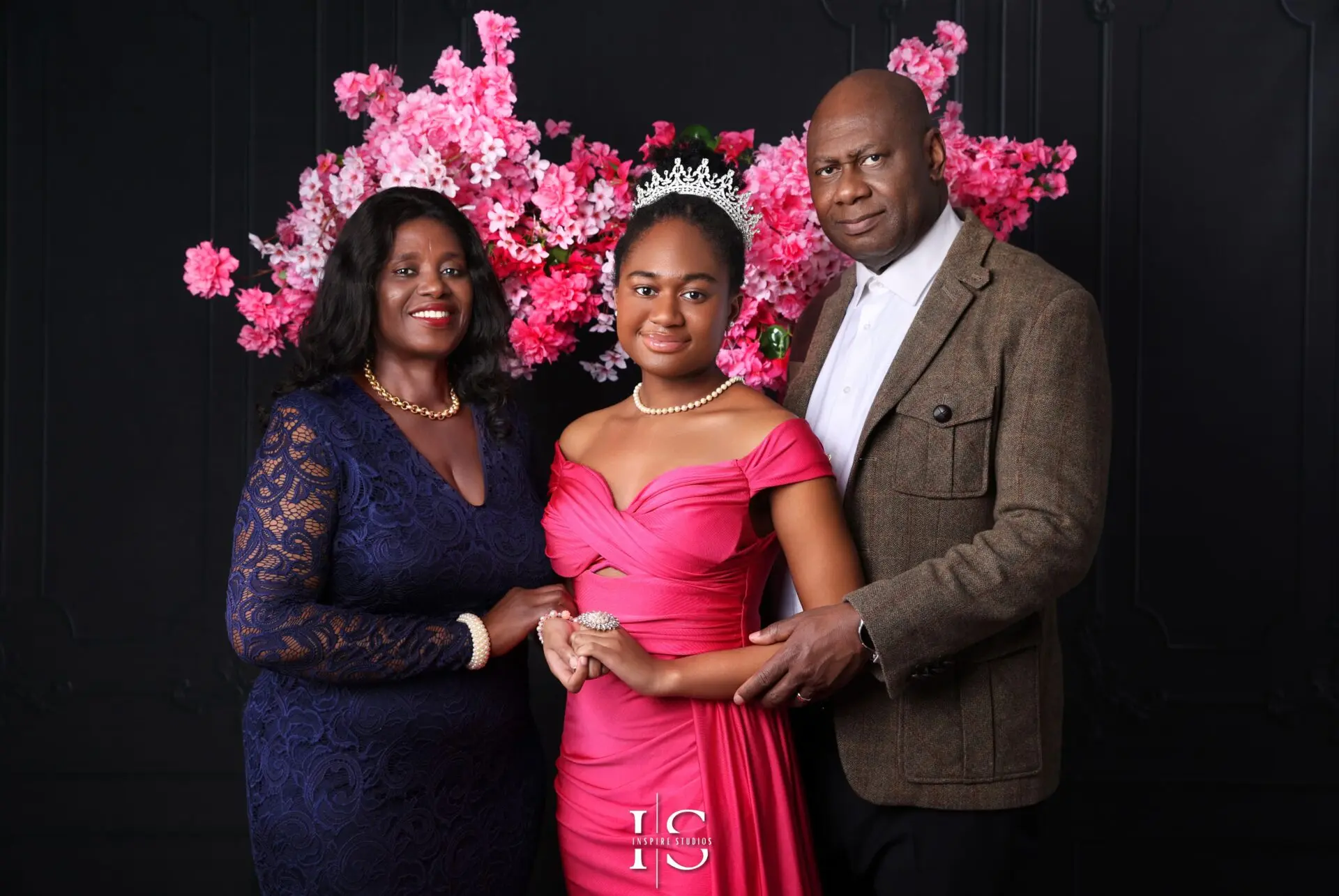 Smiling family posing together during a birthday photoshoot in a London studio with festive decorations