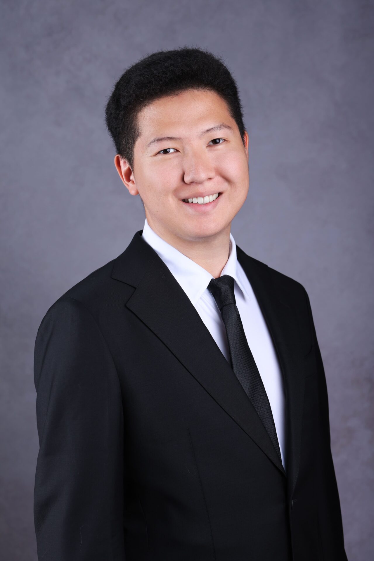 Professional man in business attire posing for a corporate headshot in a London studio.