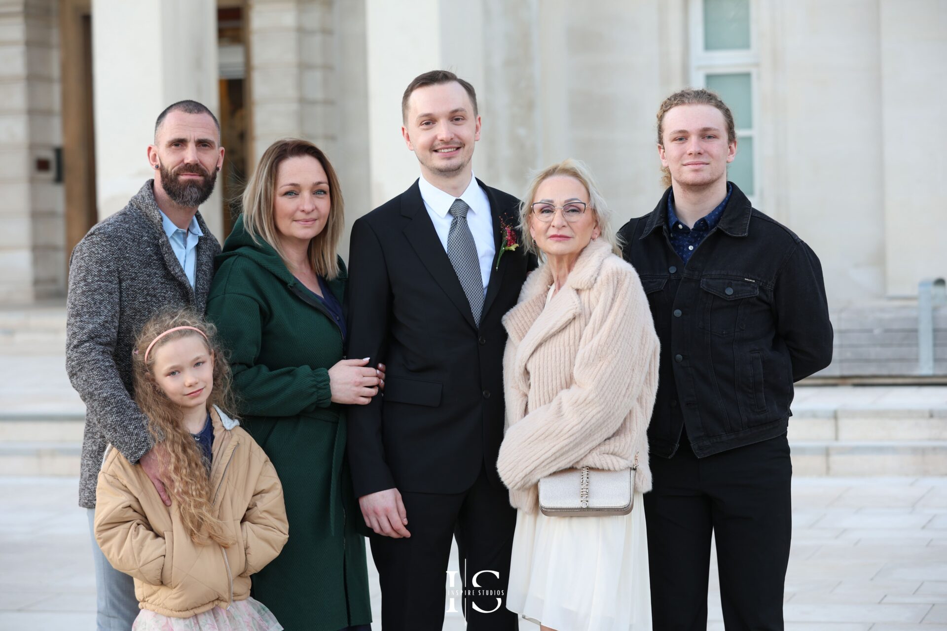 Groom posing with close family before ceremony