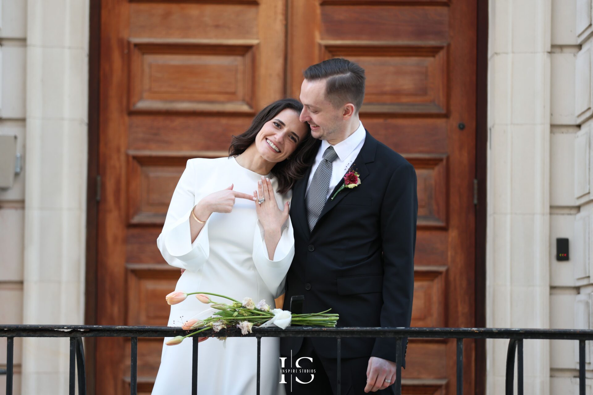 Groom twirling the bride in front of town hall during photoshoot