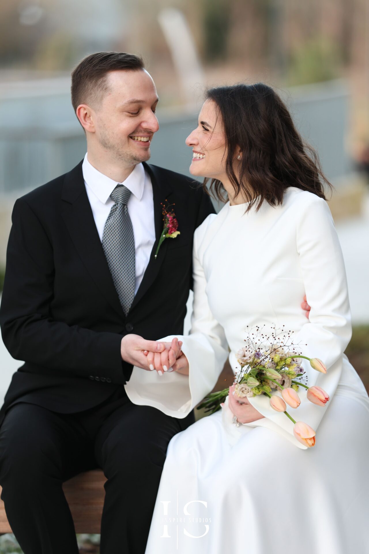 Close-up of groom fixing bride’s hair during London registry wedding, intimate candid detail