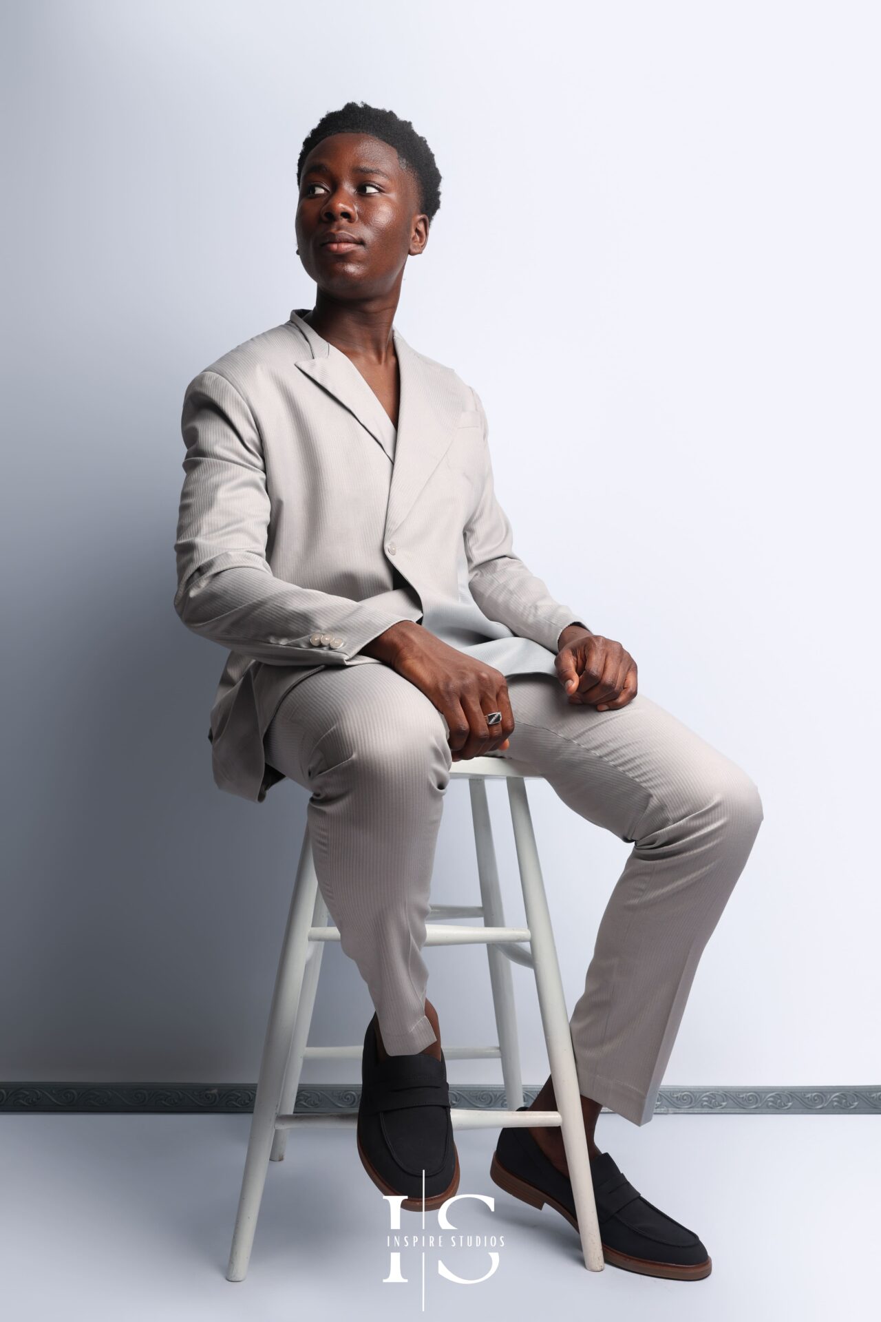 Stylish male birthday portrait against pure white background with relaxed hands‑in‑pockets pose