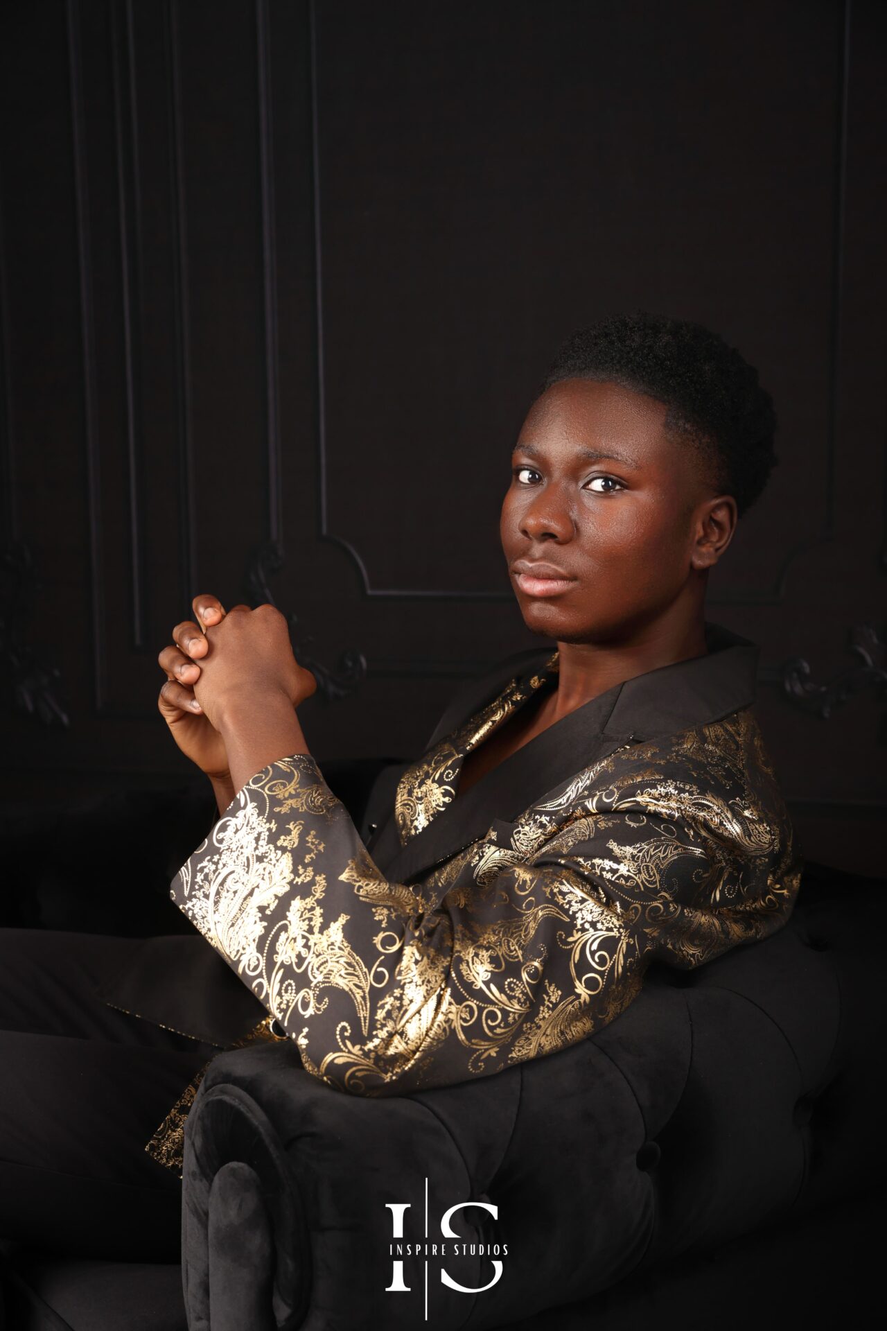 Fashion‑inspired studio image of young man seated on stool during 18th birthday session