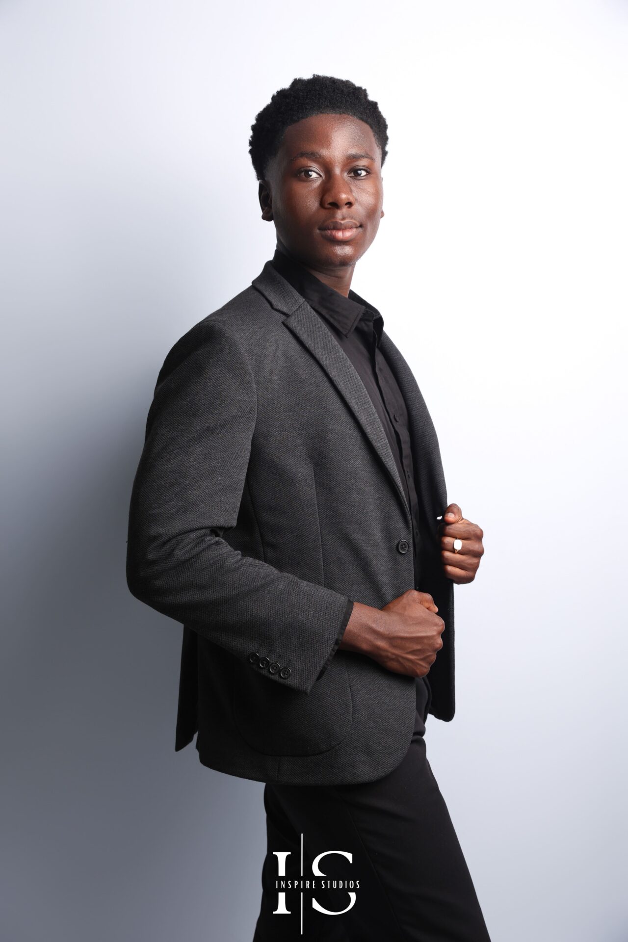 Male model in fitted black shirt posing confidently in minimalist London studio