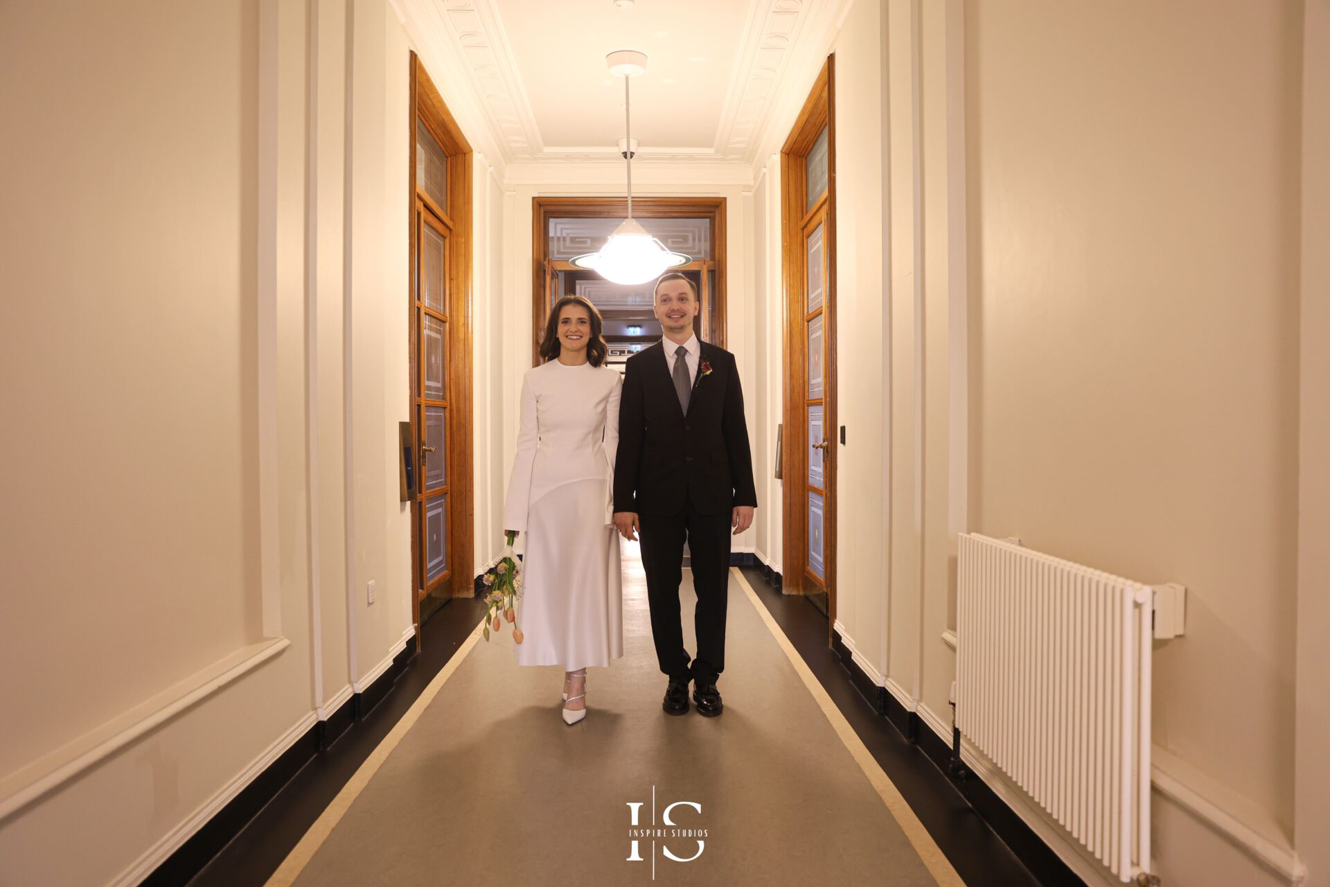 Bride and groom exiting Walthamstow Town Hall hand in hand