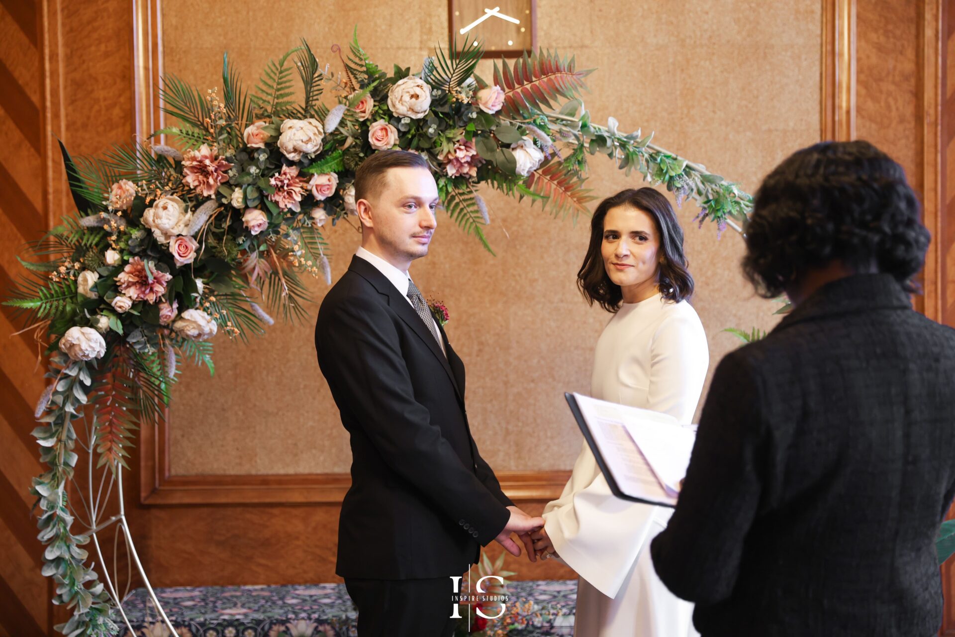 Bride and groom listening to vows during London registry wedding