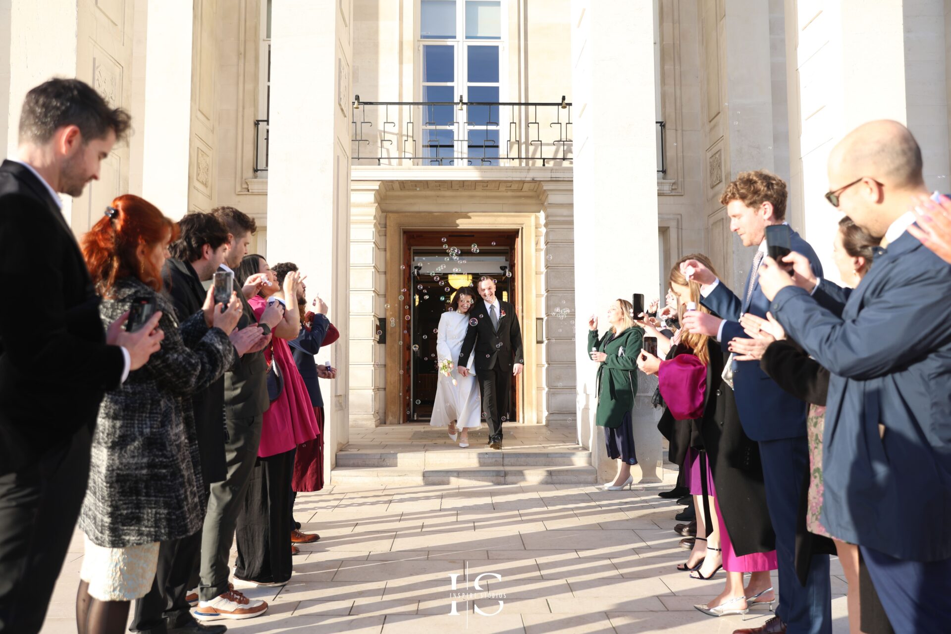 Guests clapping as bride and groom exit Walthamstow Town Hall
