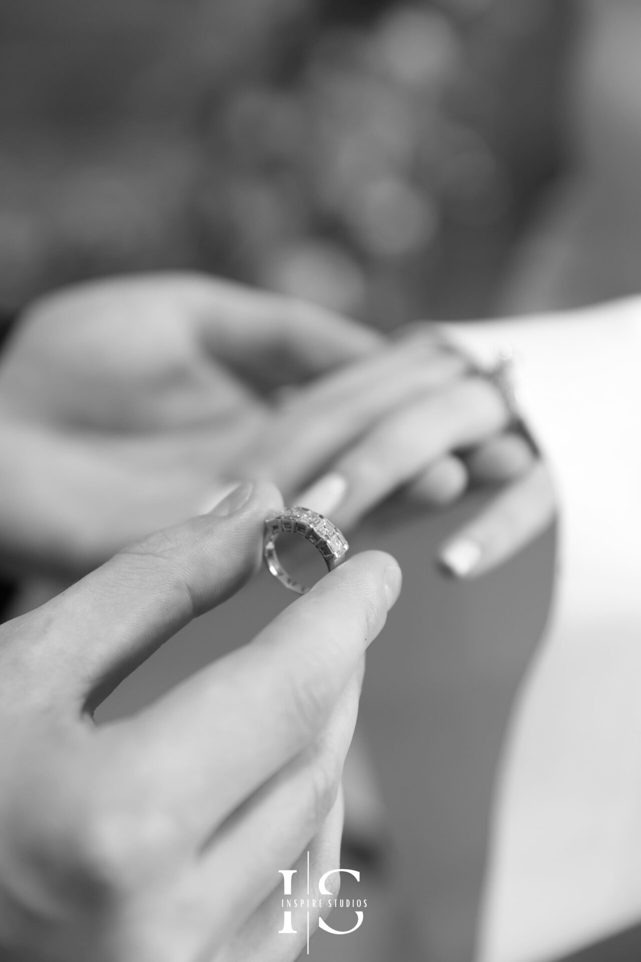 Groom places wedding band on bride’s hand at London registry