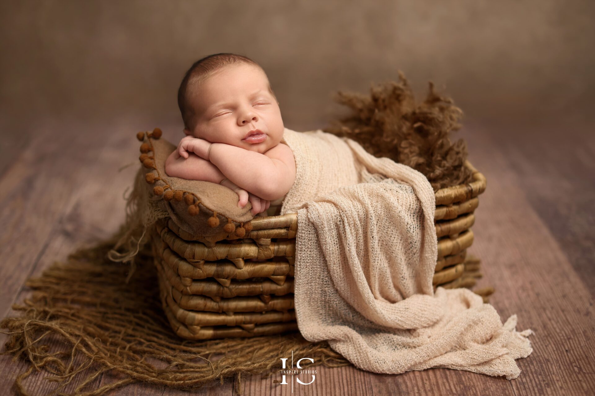 Artistic baby newborn boy photography with a cream backdrop and soft lighting