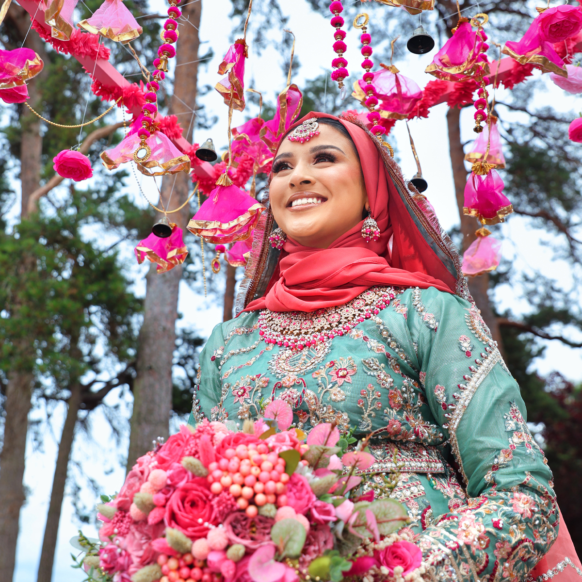 Bride holding a floral bouquet on her Mehndi Henna night, captured by a female wedding photographer in London.