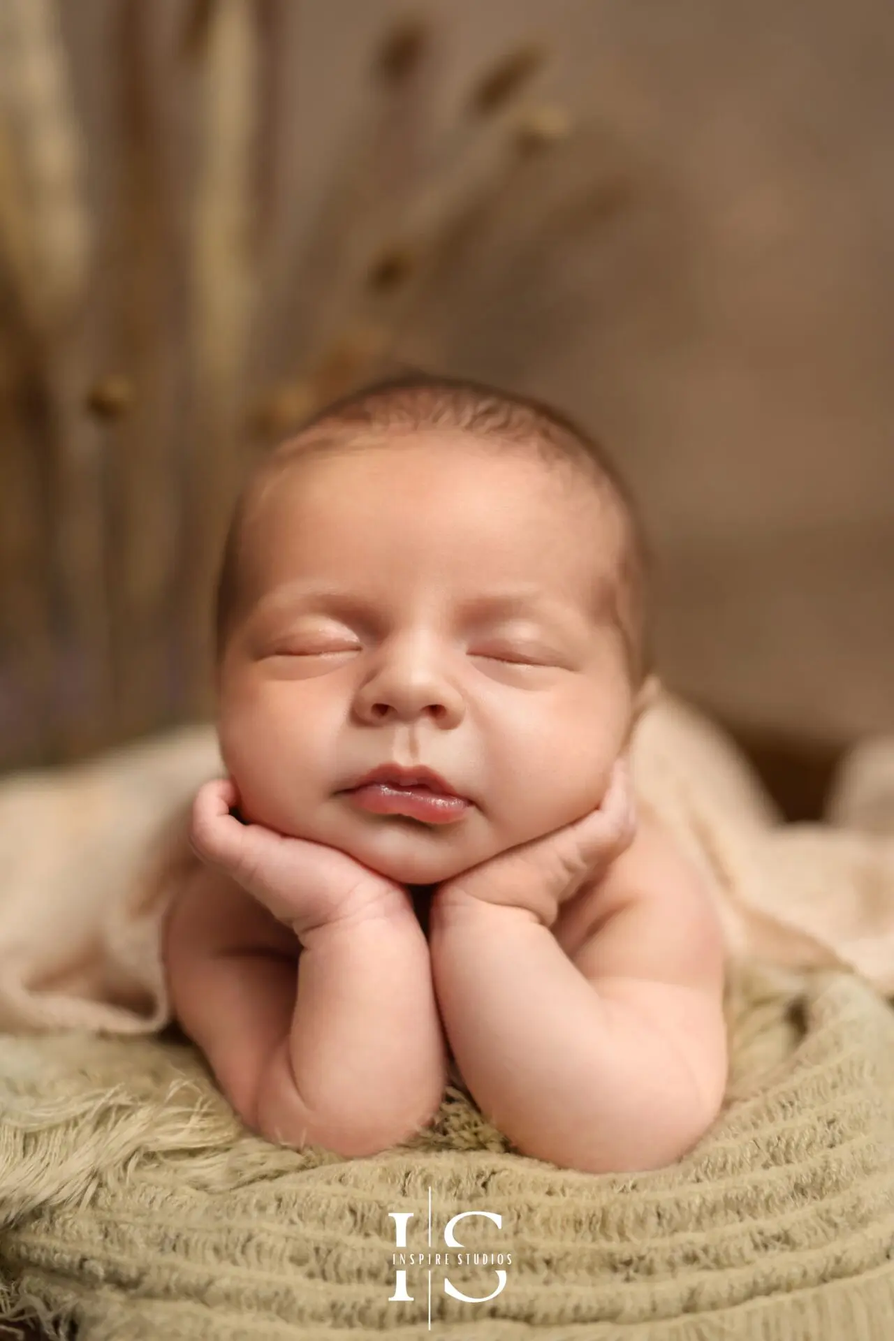Newborn photoshoot styled with textured cream blankets and boho elements