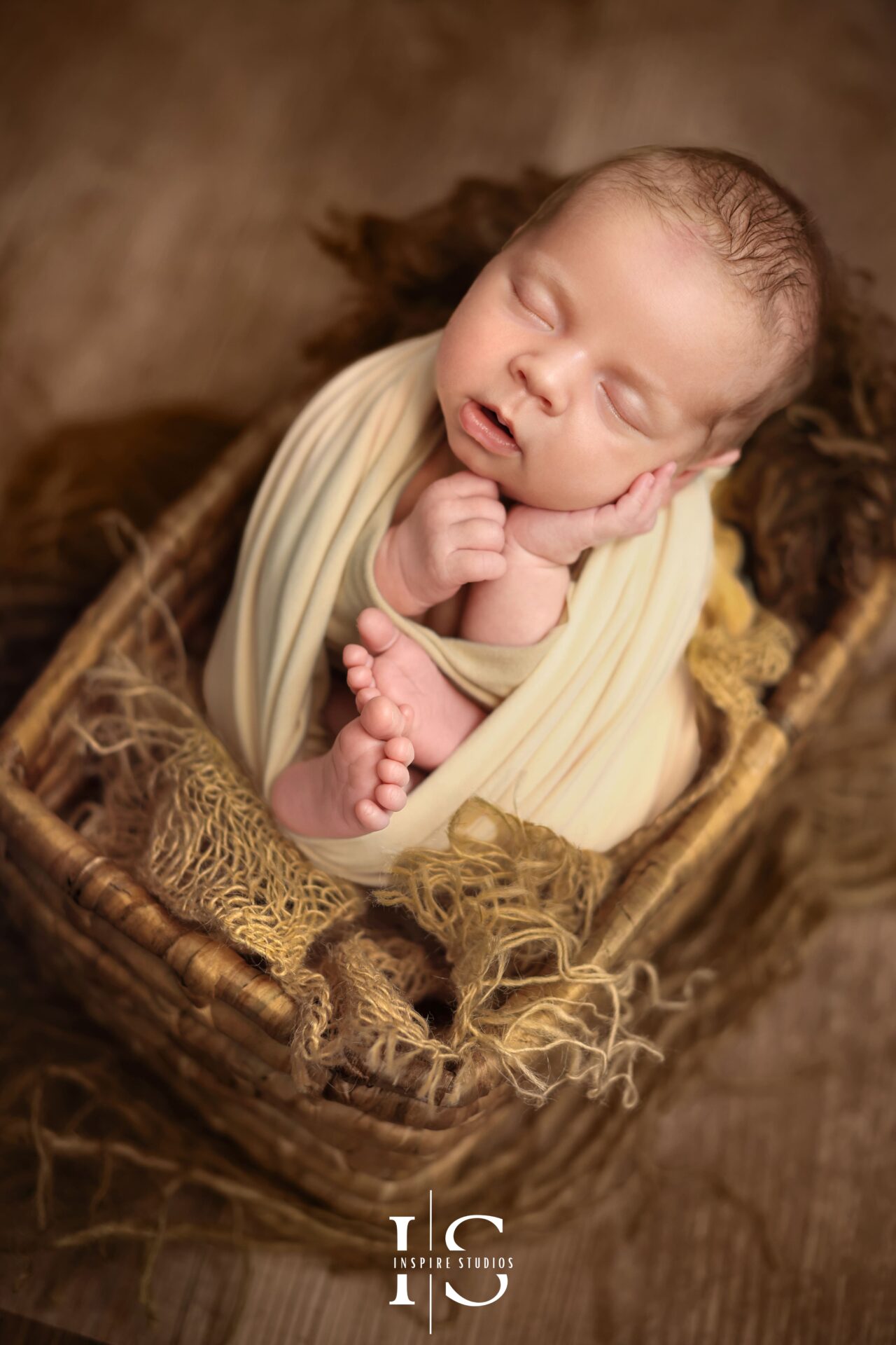 Newborn baby boy during a calm, styled photography session with neutral colors