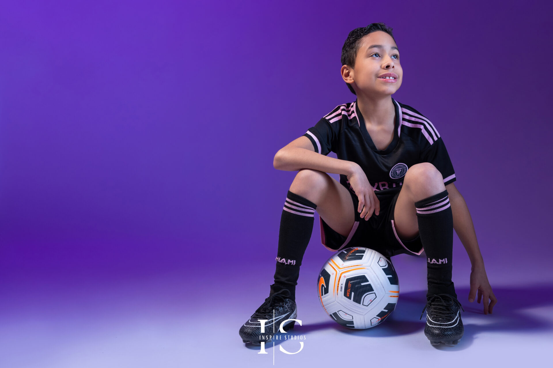 Young football fan photographed in a studio with creative sports styling.