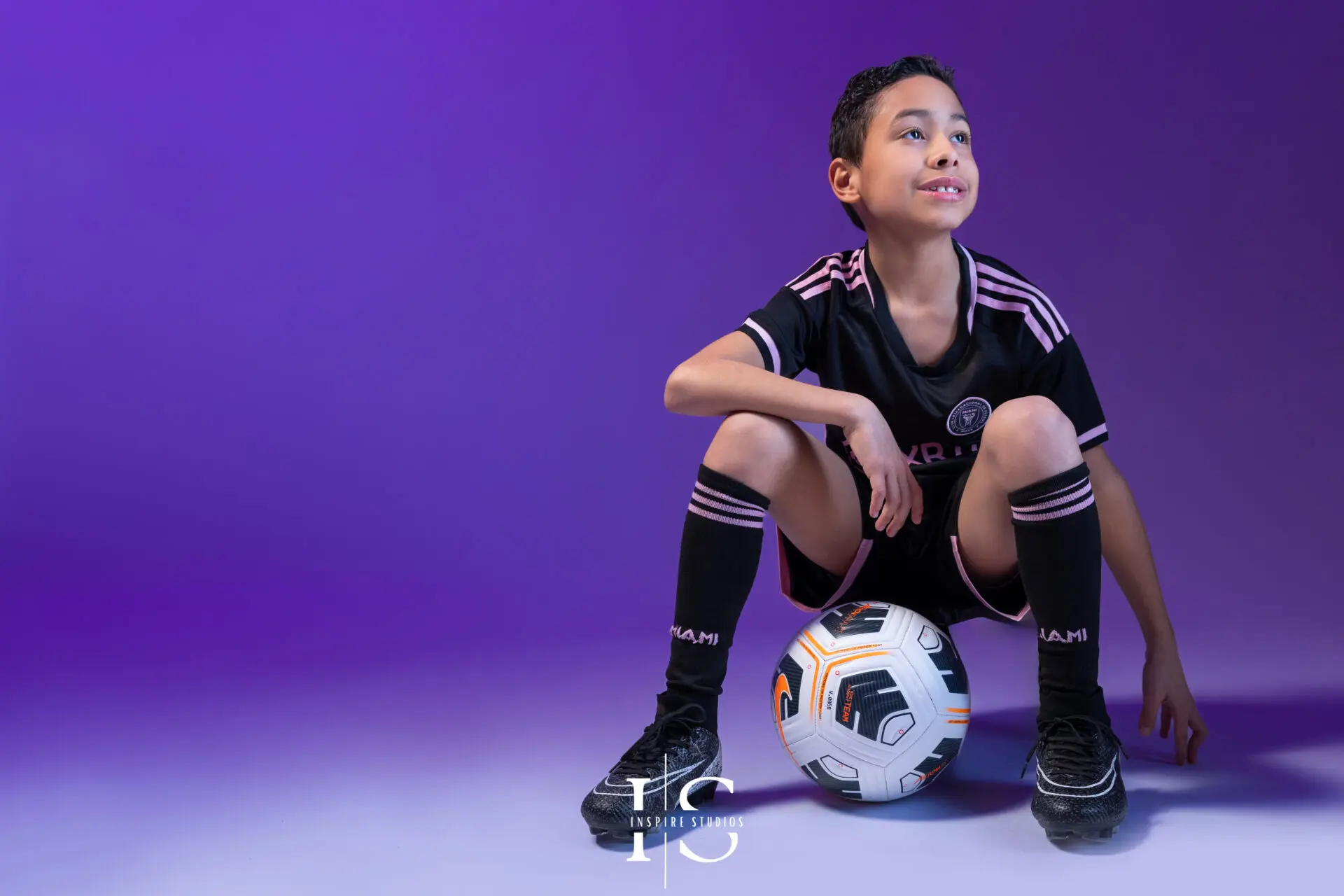 Young football fan photographed in a studio with creative sports styling.