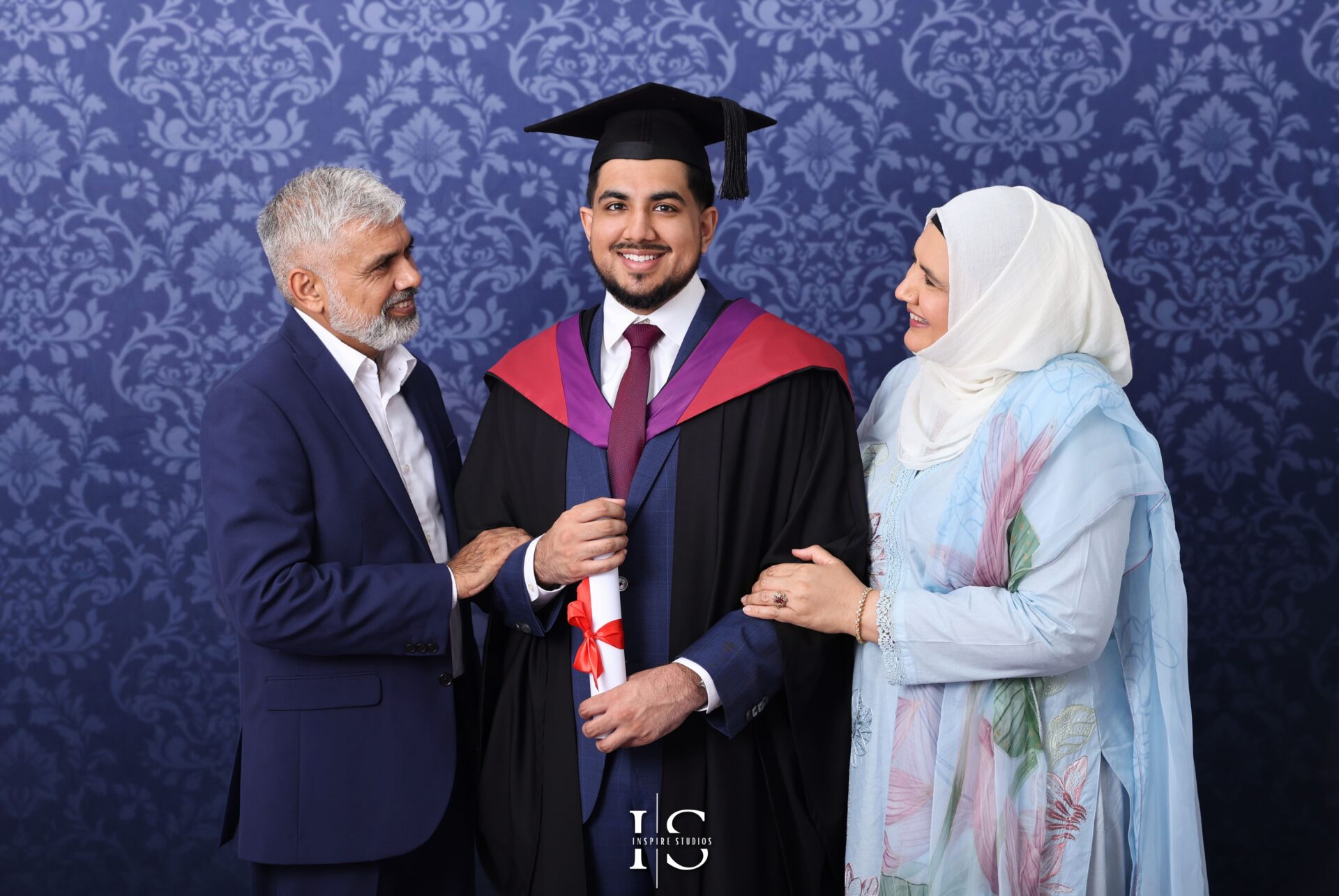 Graduate hugging family members during studio graduation photoshoot