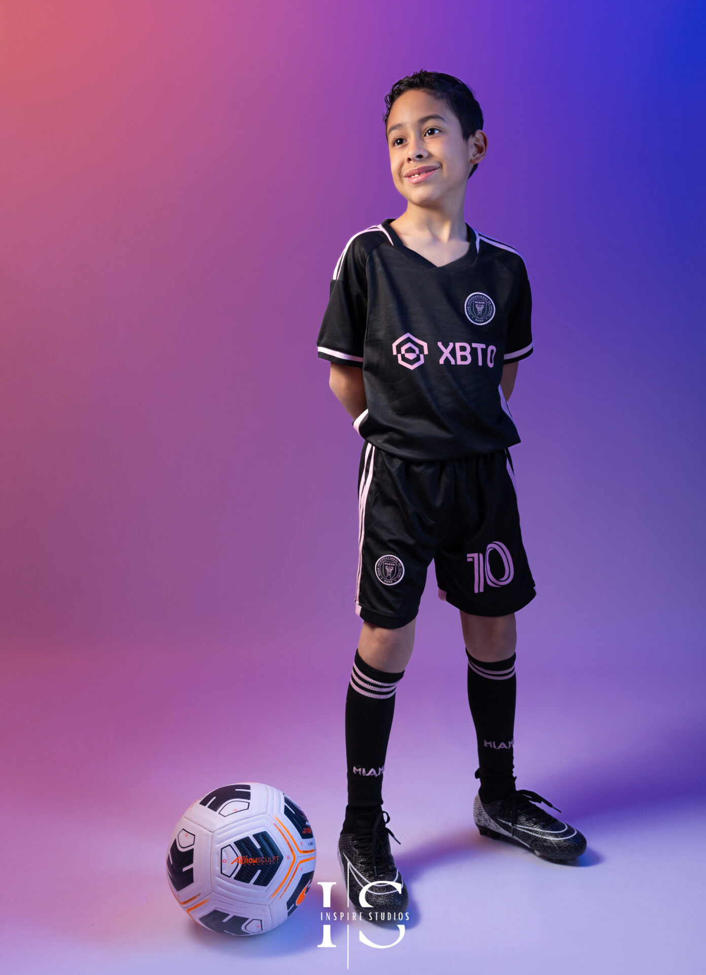 Child enjoying a fun football-themed studio photography session in London.