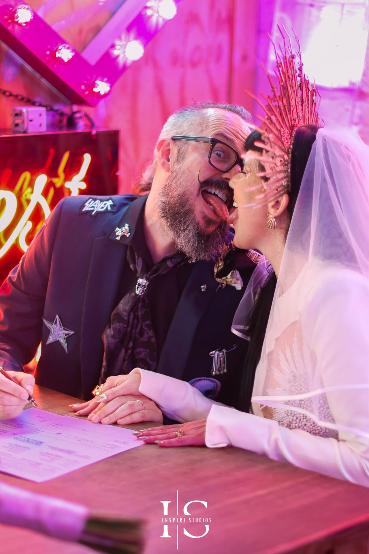 Bride and groom signing registry documents at Gods Own Junkyard wedding