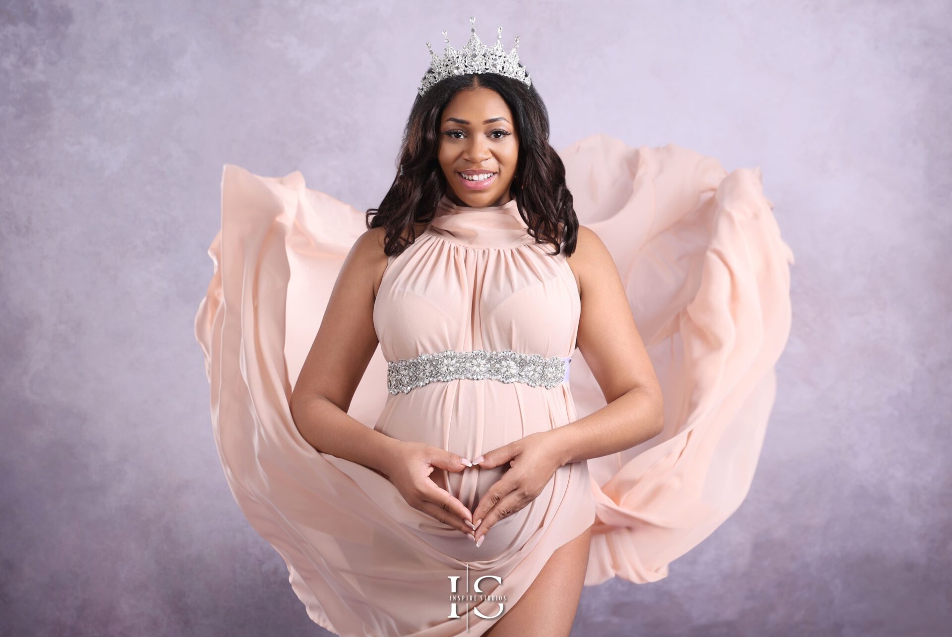 Professional maternity studio photoshoot in London with a flowing pink maternity gown.