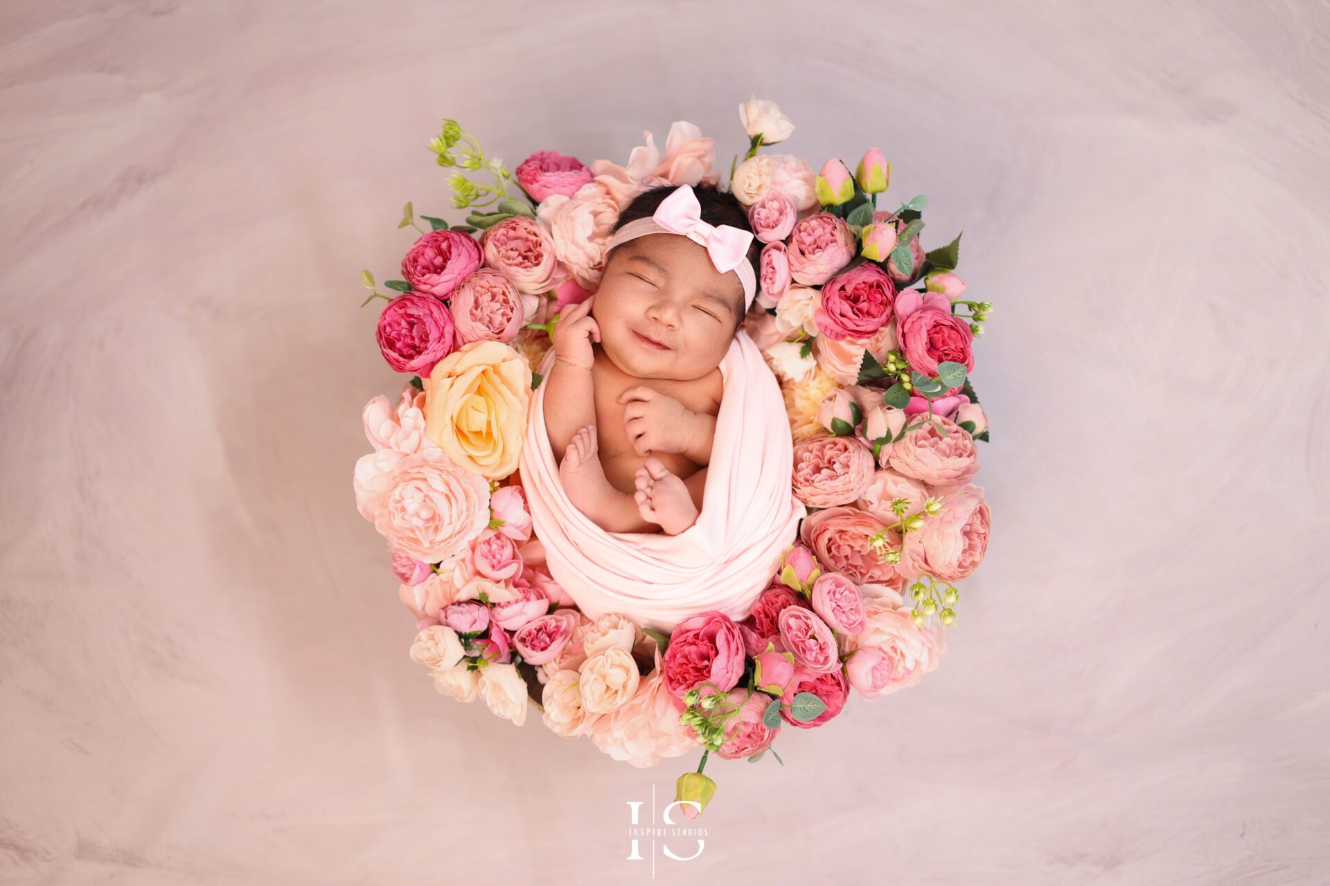 Sleeping baby girl in a cozy wrap at a professional studio session.