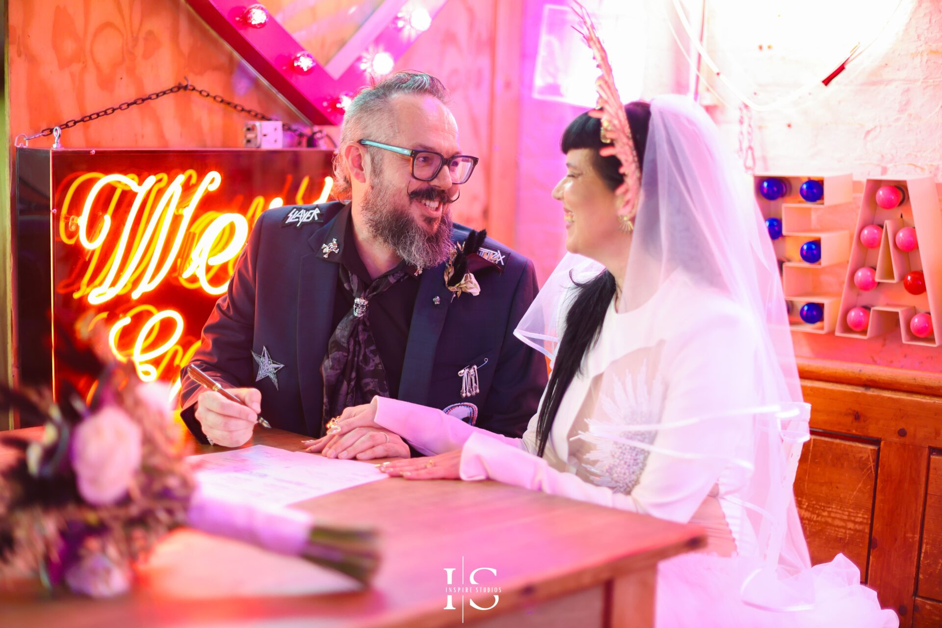 Close-up of bride and groom signing registry at punk wedding in London