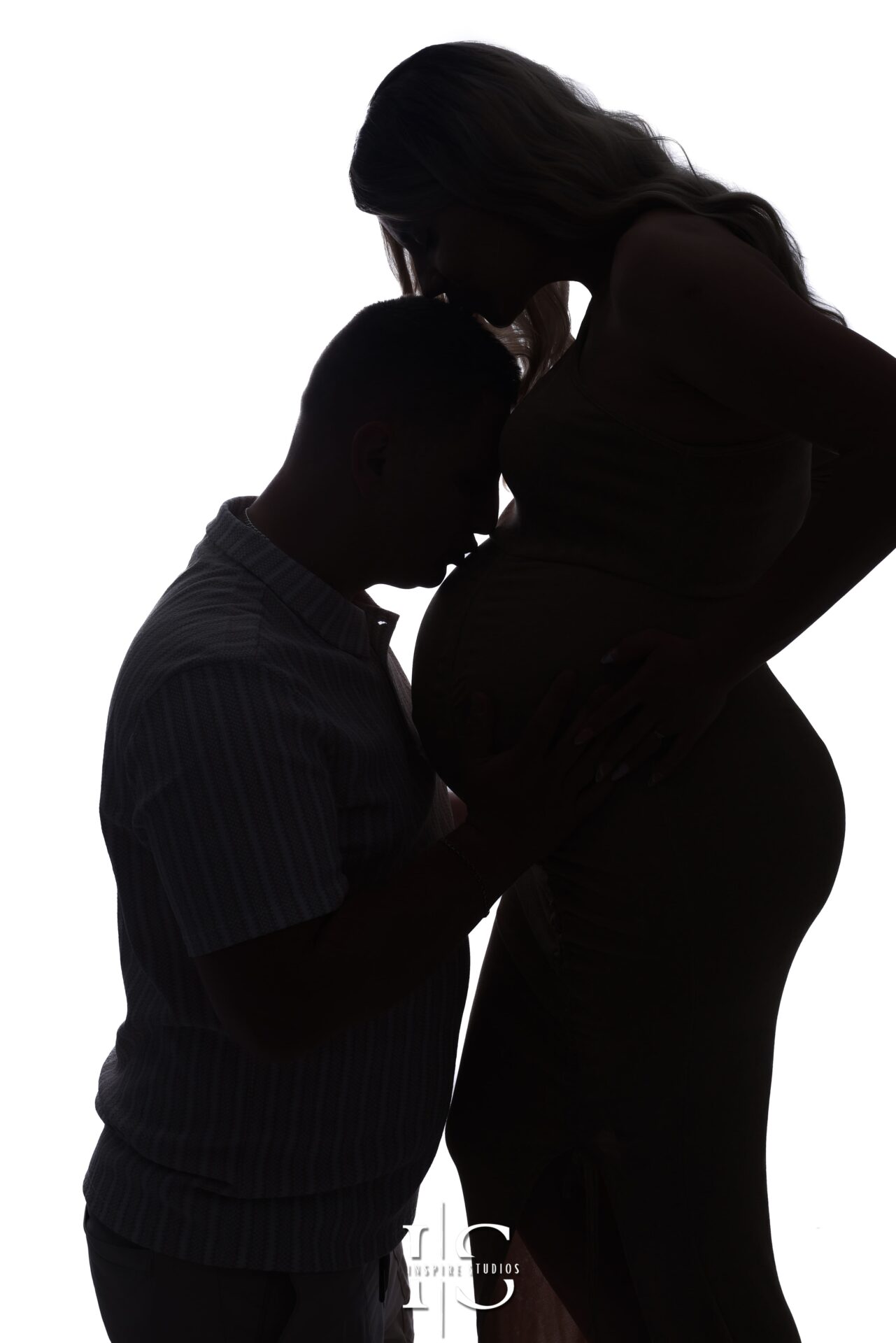 Silhouette of an expecting couple during maternity photoshoot