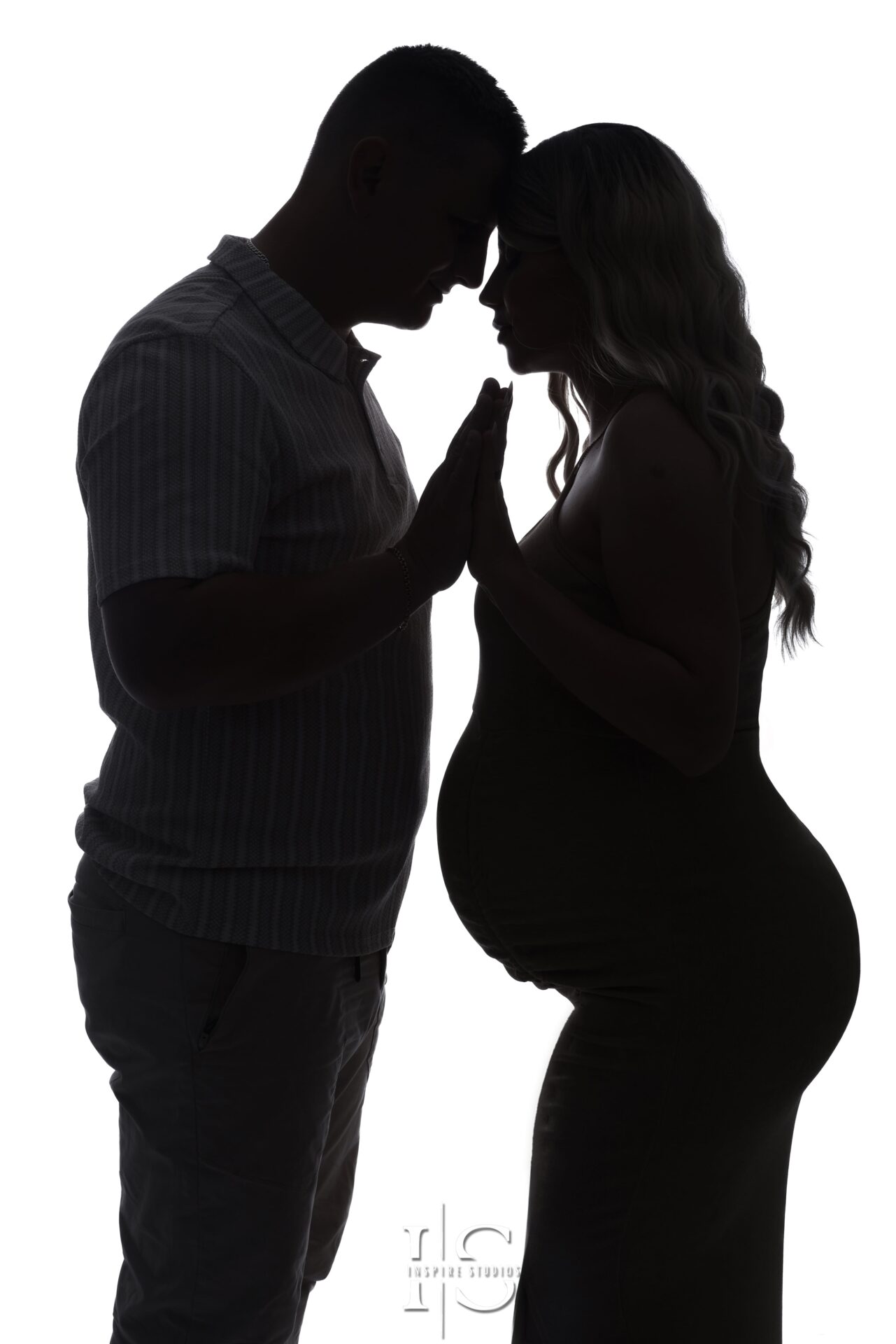 Studio maternity photoshoot featuring artistic silhouette portrait