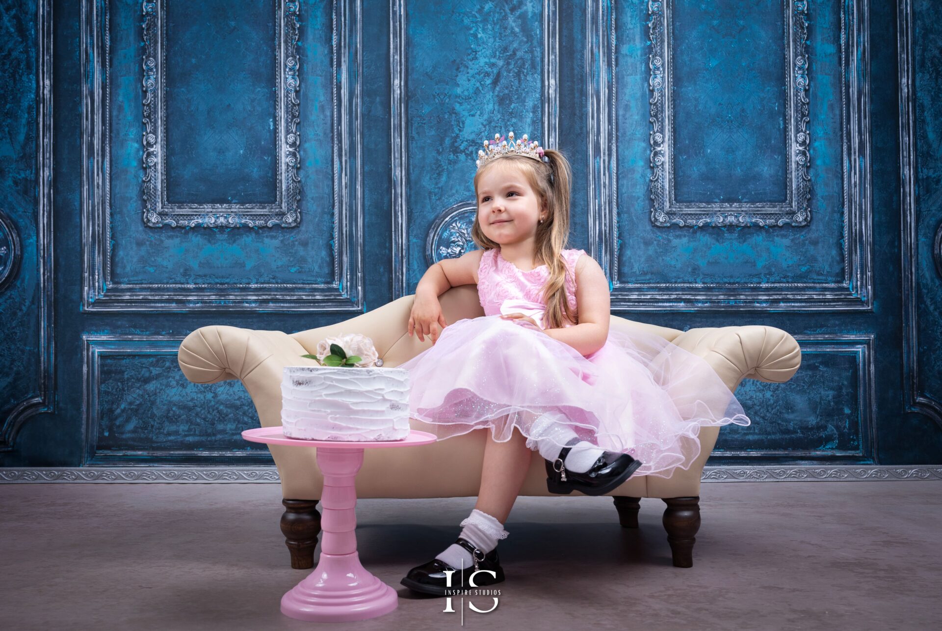 A joyful 4-year-old girl enjoying her birthday photoshoot with balloons, flowers, and a cake table.