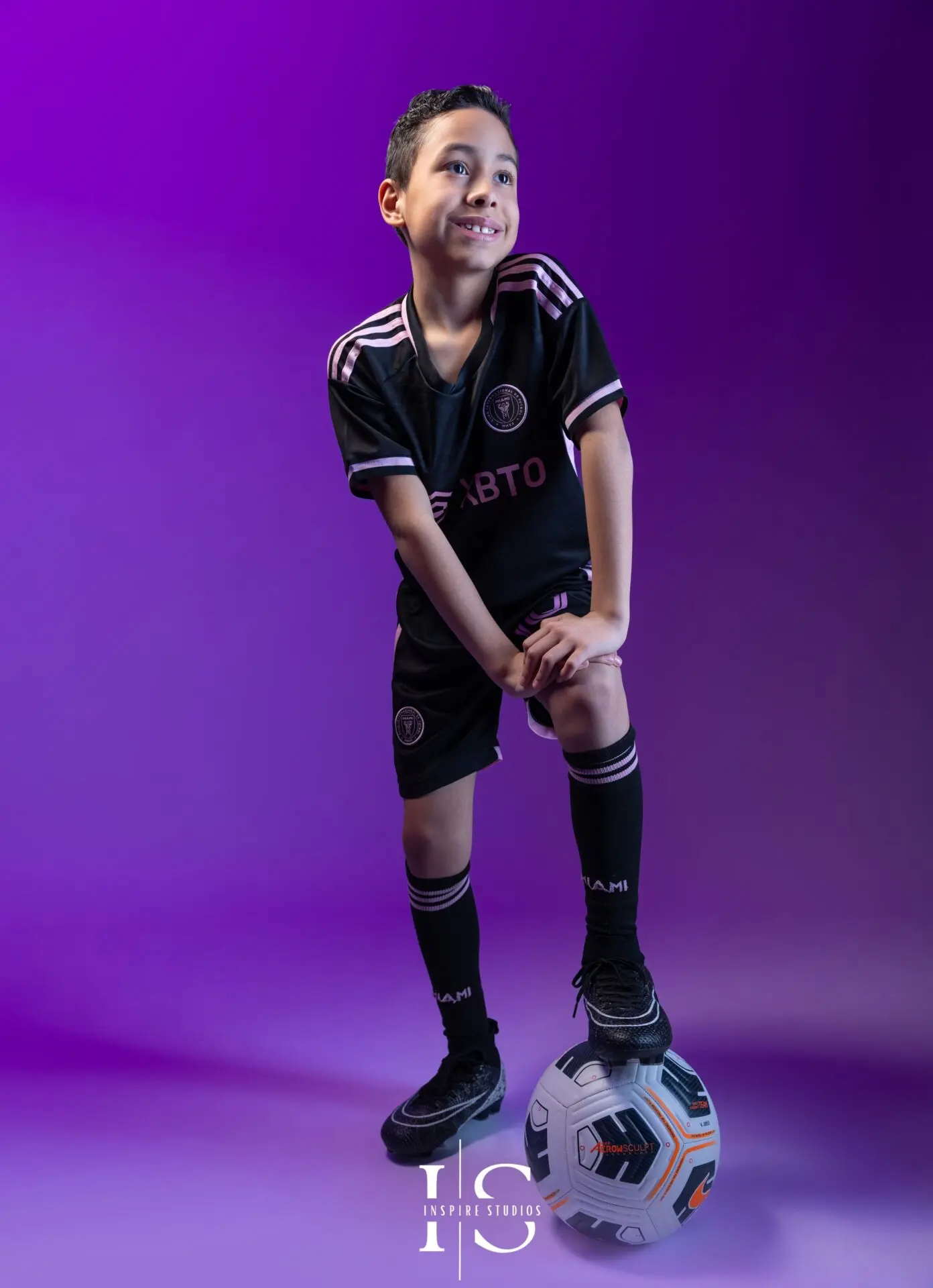 Child striking action football pose in professional studio session