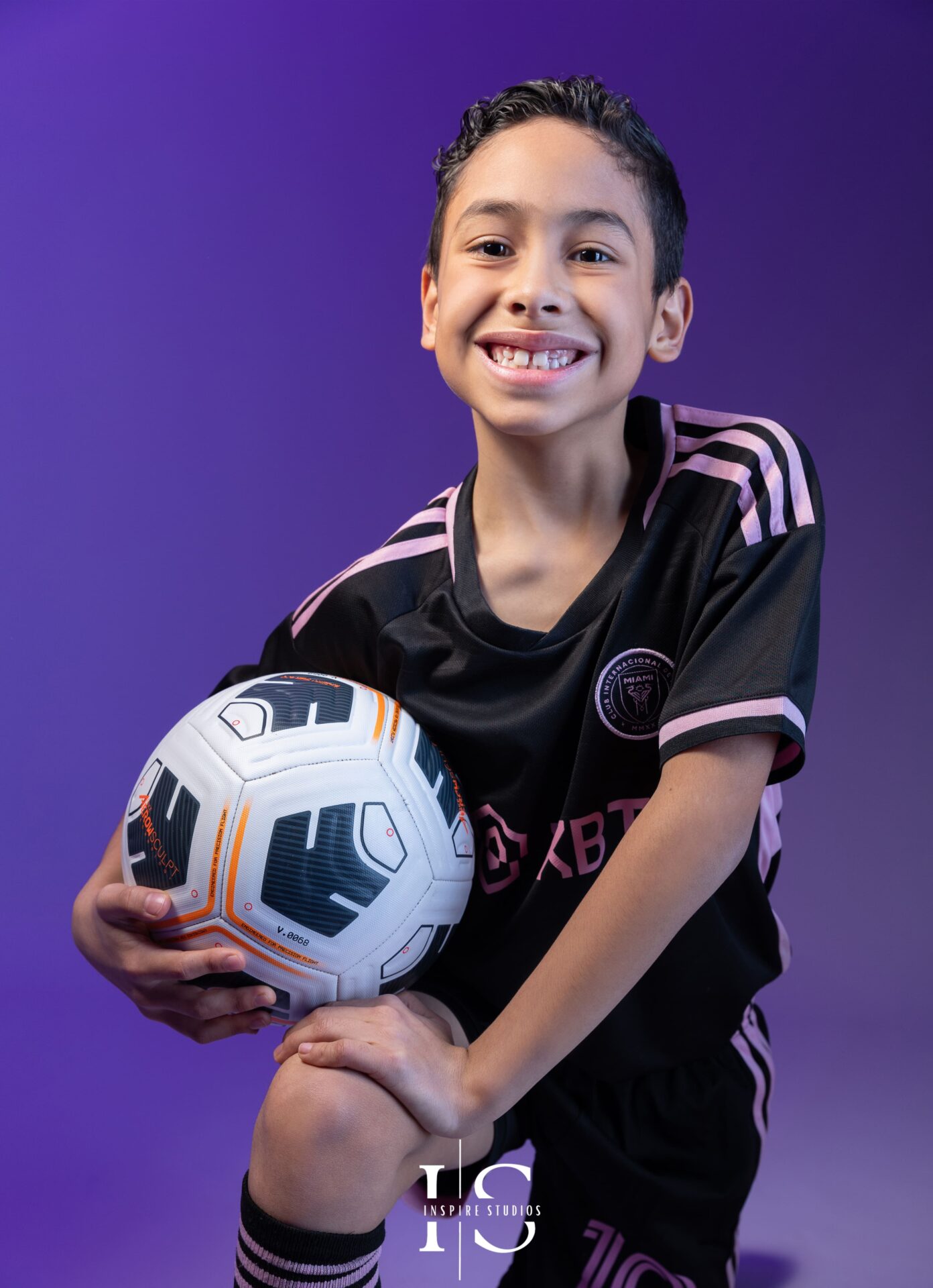 Child in sports-inspired studio photoshoot London with football props