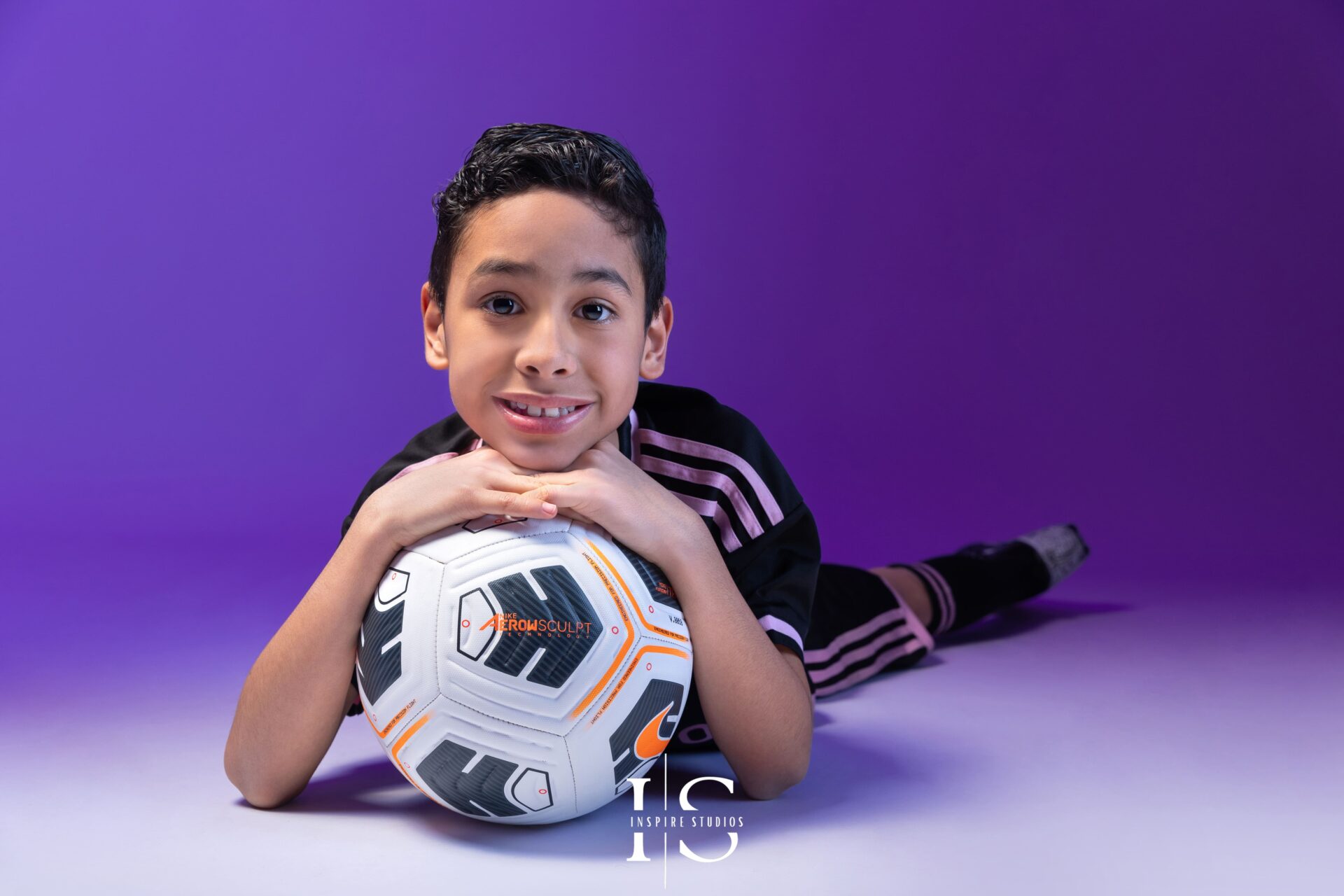 Kid posing in a football-themed studio photoshoot in London