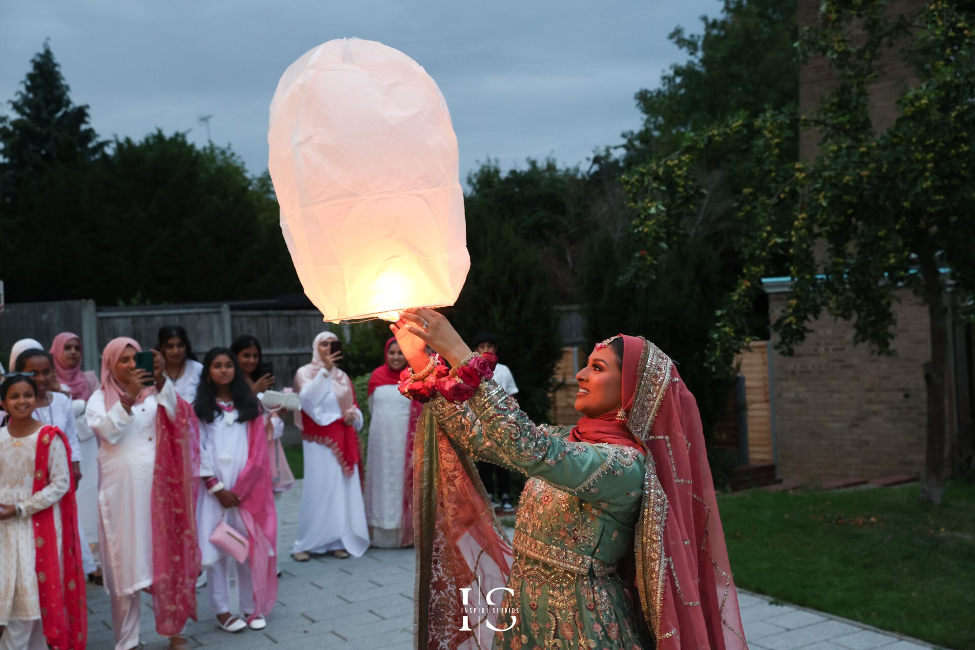 London Mehndi bride holding a lampion during night celebration.