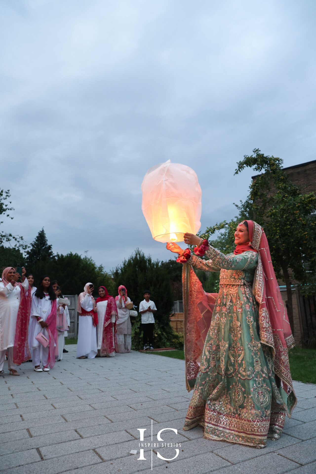 Mehndi bride releases lantern during London wedding celebration.