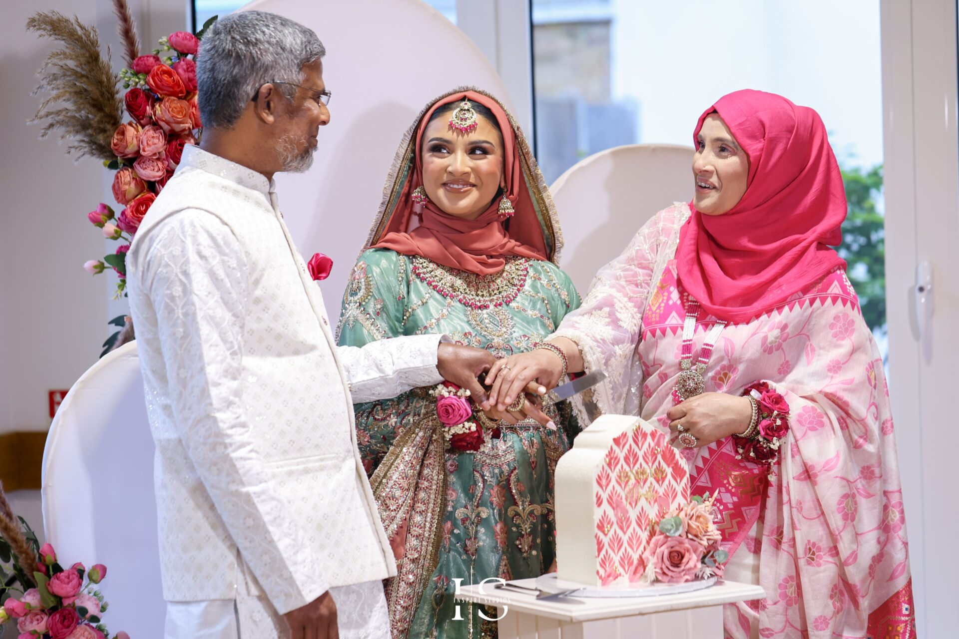 Mehndi bride cuts wedding cake during London ceremony.