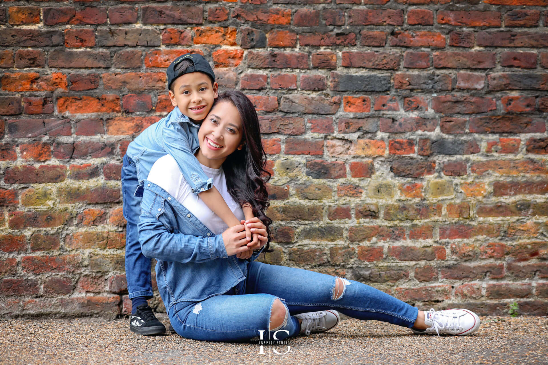 Candid portrait of a mother and son laughing together outdoors at Valentines Park, London.