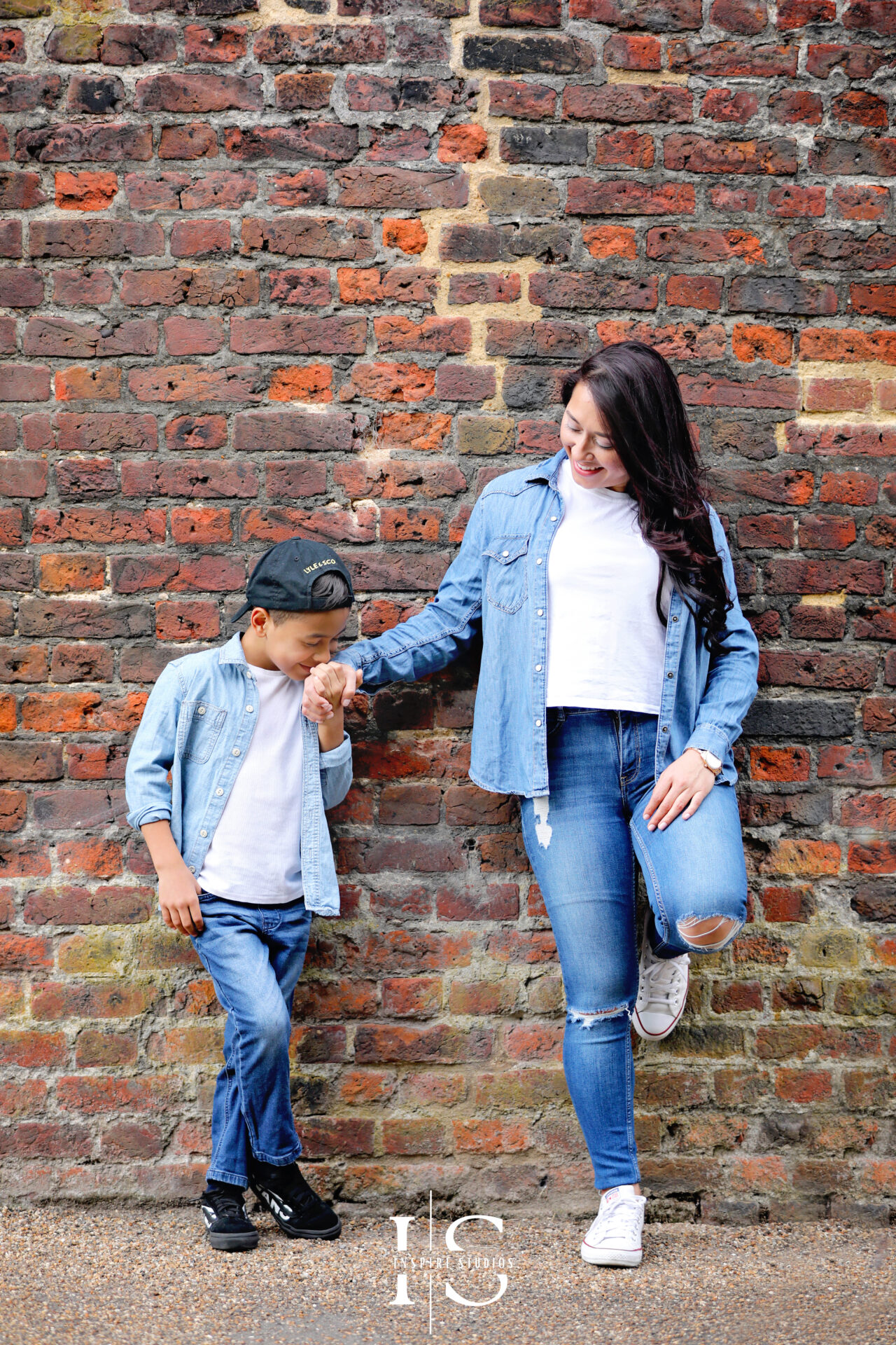 Outdoor photography of a mother and son enjoying playful moments in a park.
