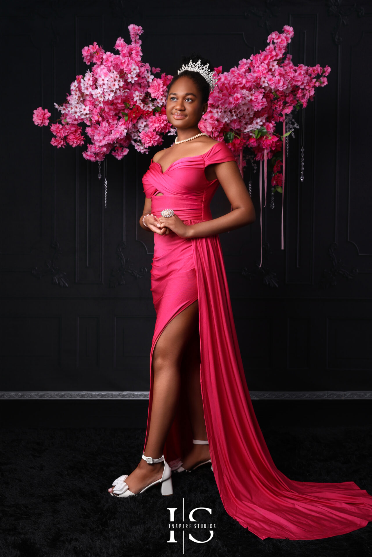Birthday girl wearing a pink birthday dress, sitting in a studio photoshoot.