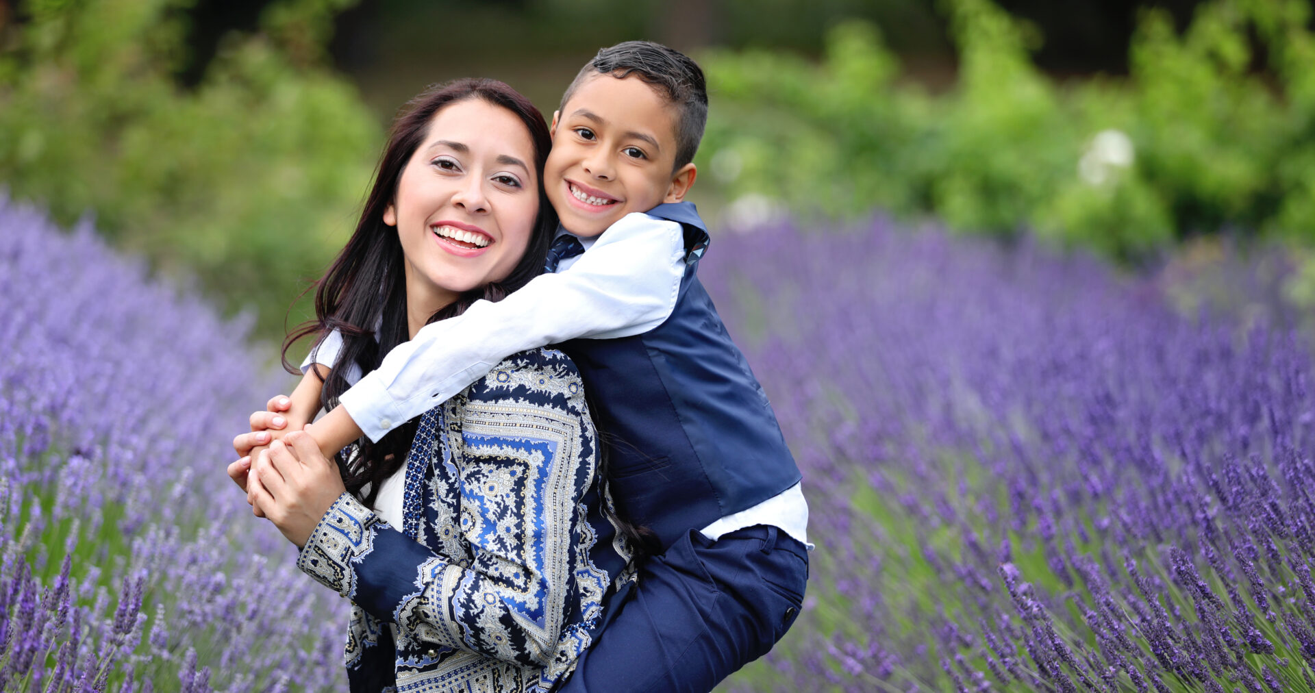 Family enjoying an outdoor photoshoot surrounded by greenery at Valentines Park, London.