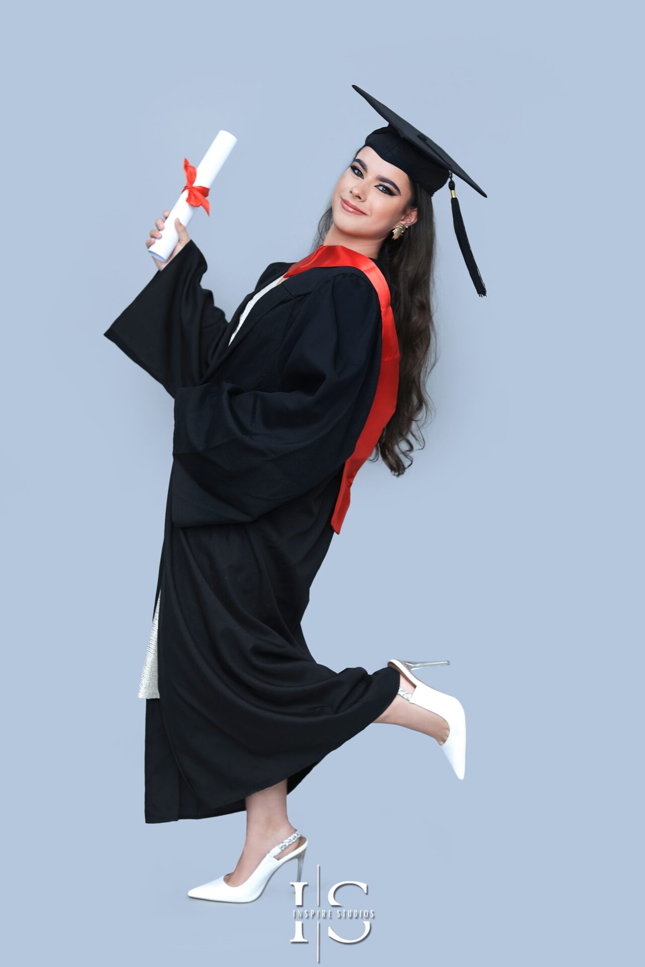 Graduation studio photoshoot in Walthamstow featuring student posing in studio with cap and gown