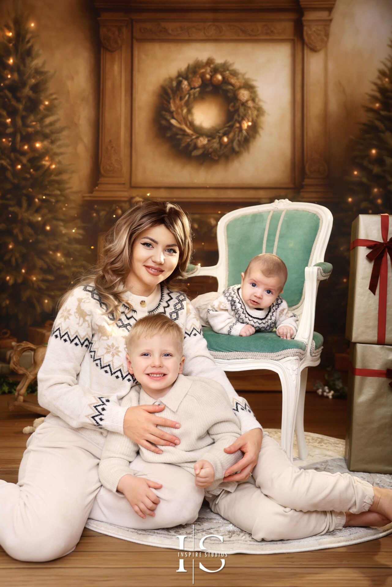 Family posing together during Christmas studio photoshoot in London 2025 against Inspire Studios Boho Christmas backdrop
