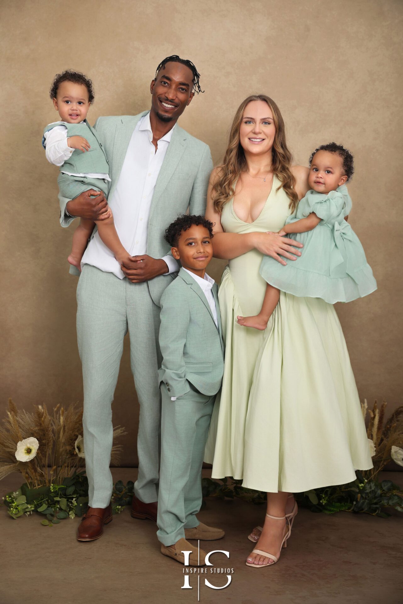 Happy family posing for a professional studio photoshoot in London with soft lighting and modern backdrop