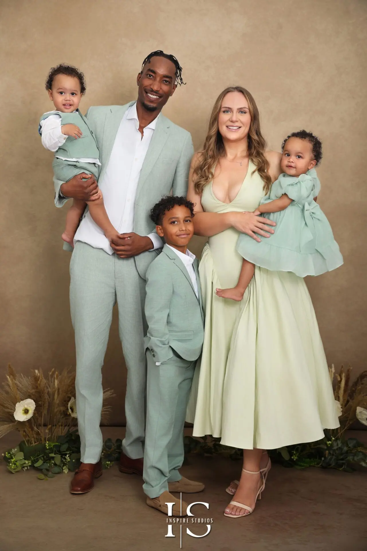 Happy family posing for a professional studio photoshoot in London with soft lighting and modern backdrop