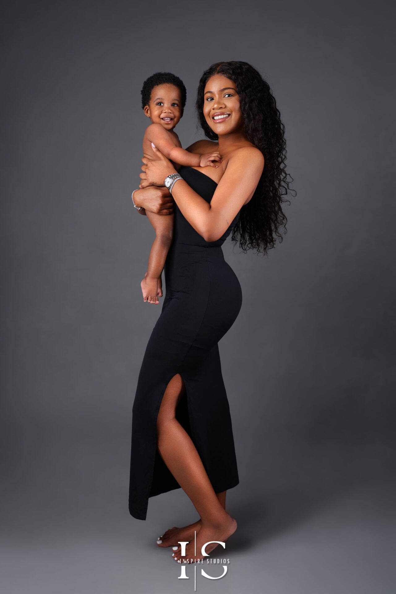 Fine art portrait of mother and son in a studio setting with dramatic lighting and emotional expression