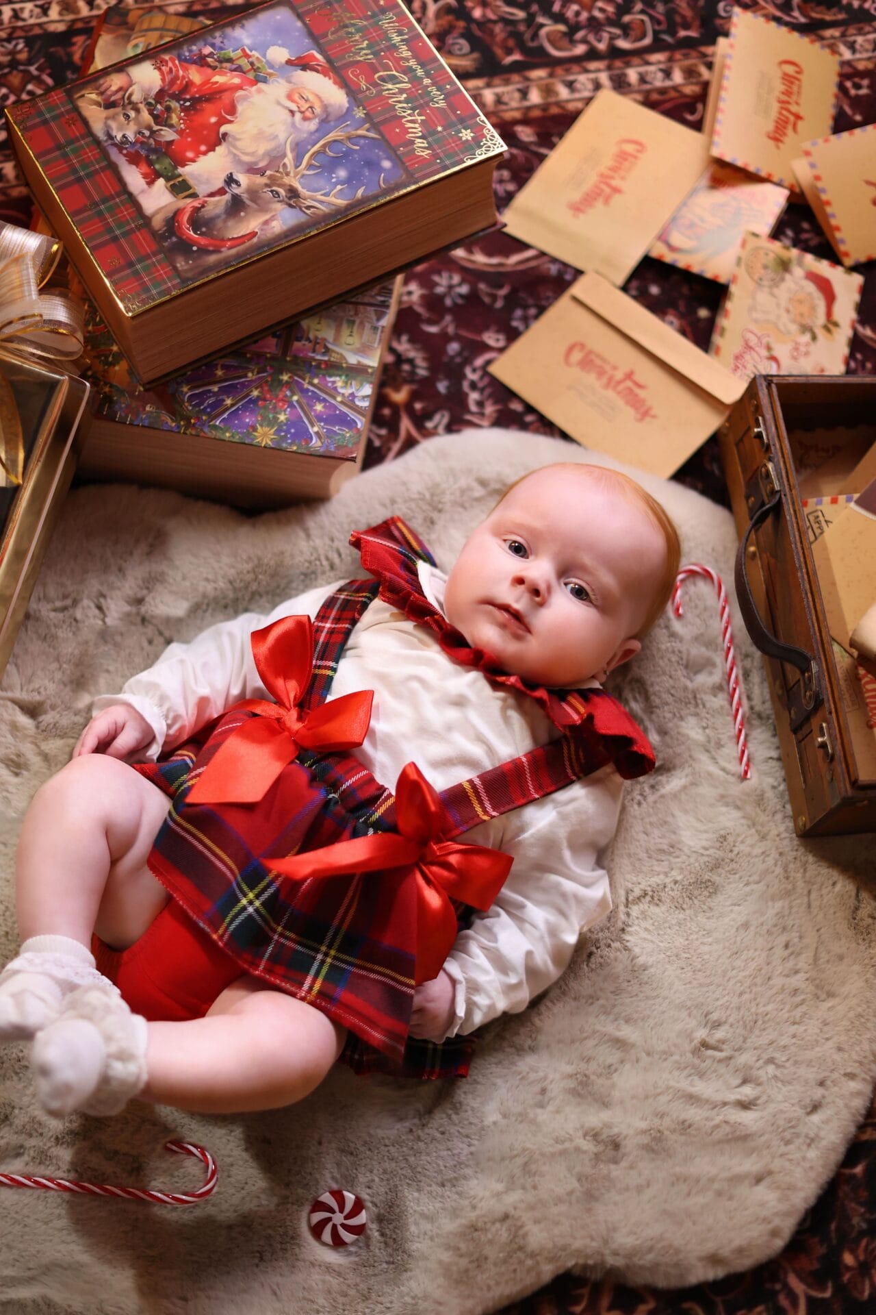 Five-month-old baby during a Christmas photoshoot in London, surrounded by festive decorations and soft winter lighting.