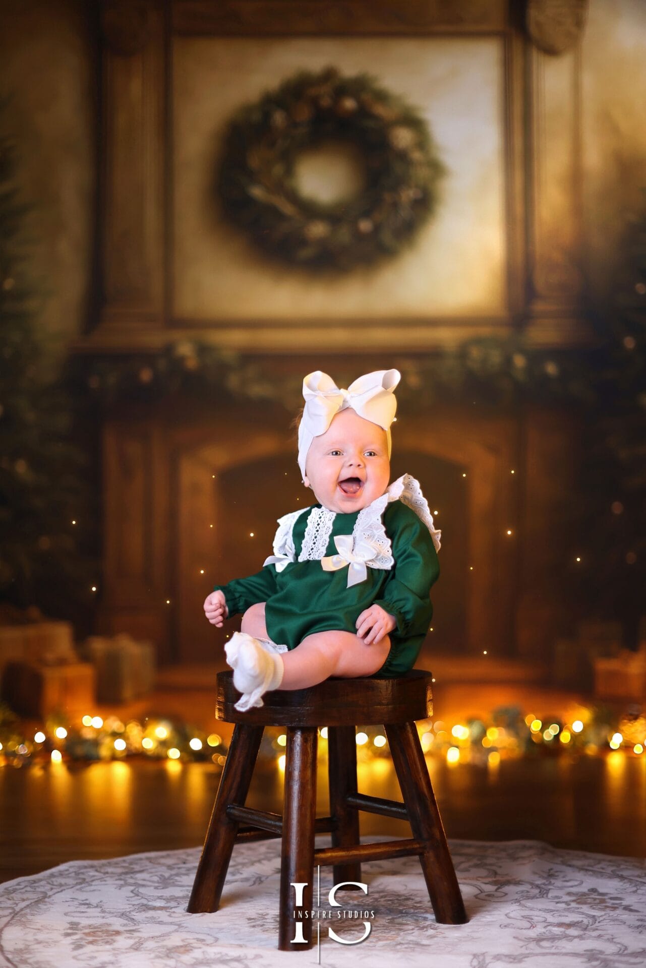 Baby celebrating their first Christmas in a festive portrait with holiday decorations and warm seasonal lights.