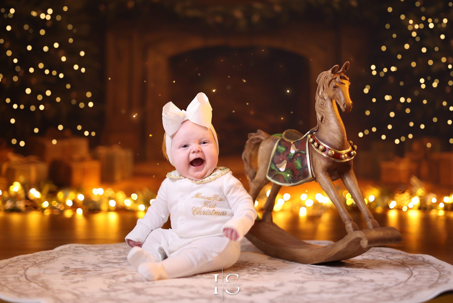 Newborn or infant posing for Baby’s First Christmas studio portrait with Christmas props and winter-themed décor.
