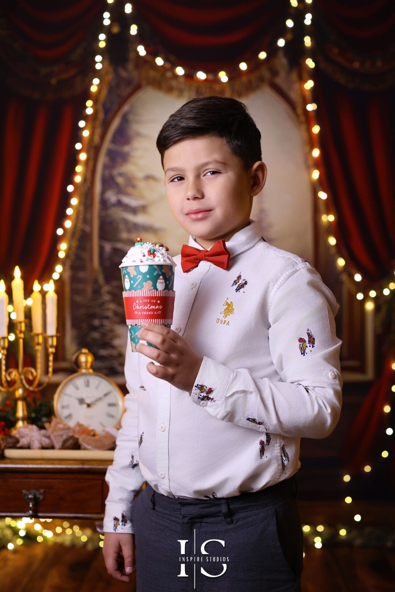 Smiling children in festive Christmas outfits posing for a holiday portrait by a decorated Christmas tree