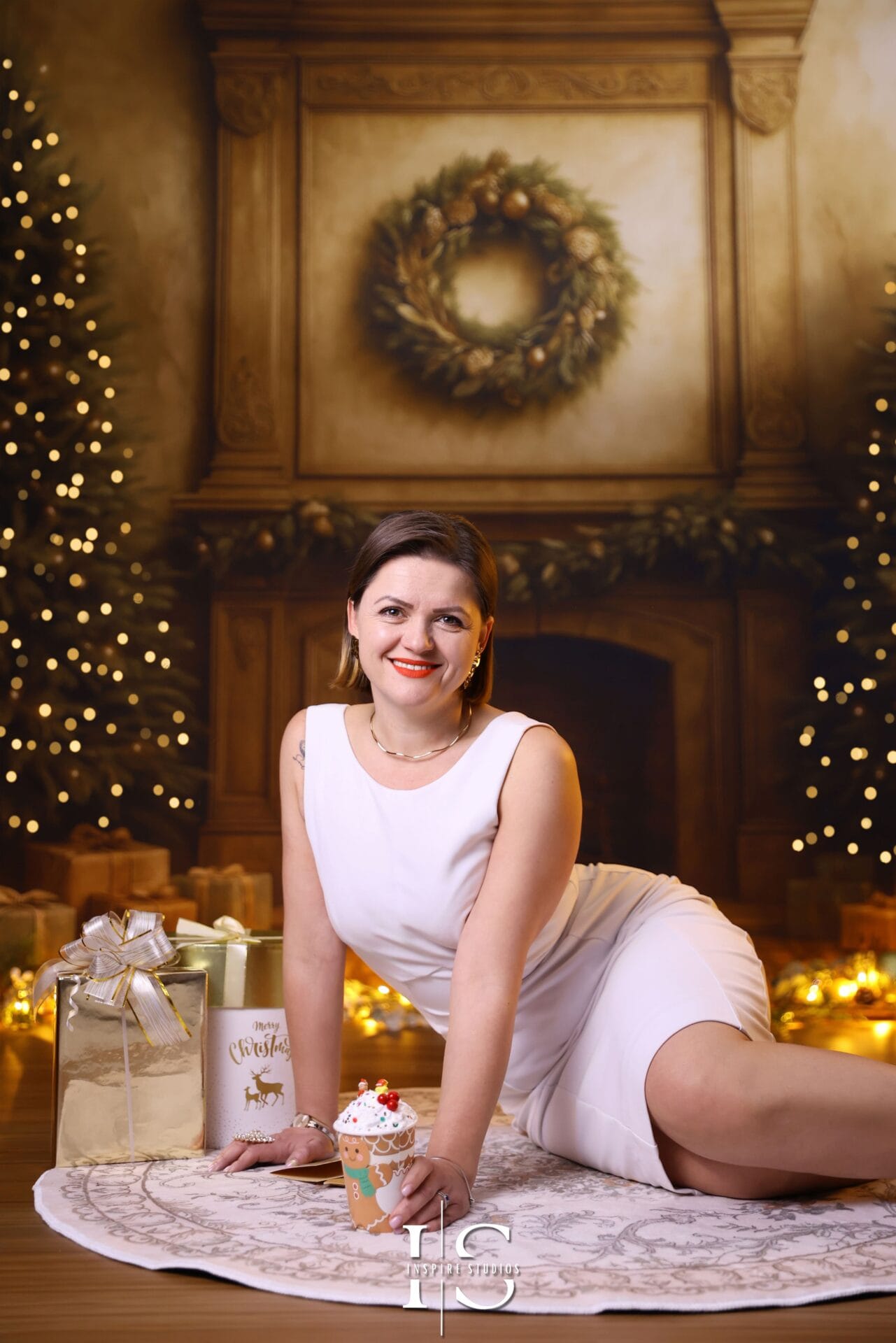 Family posing together in a festive Christmas studio with holiday décor, warm lighting, and coordinated seasonal outfits.