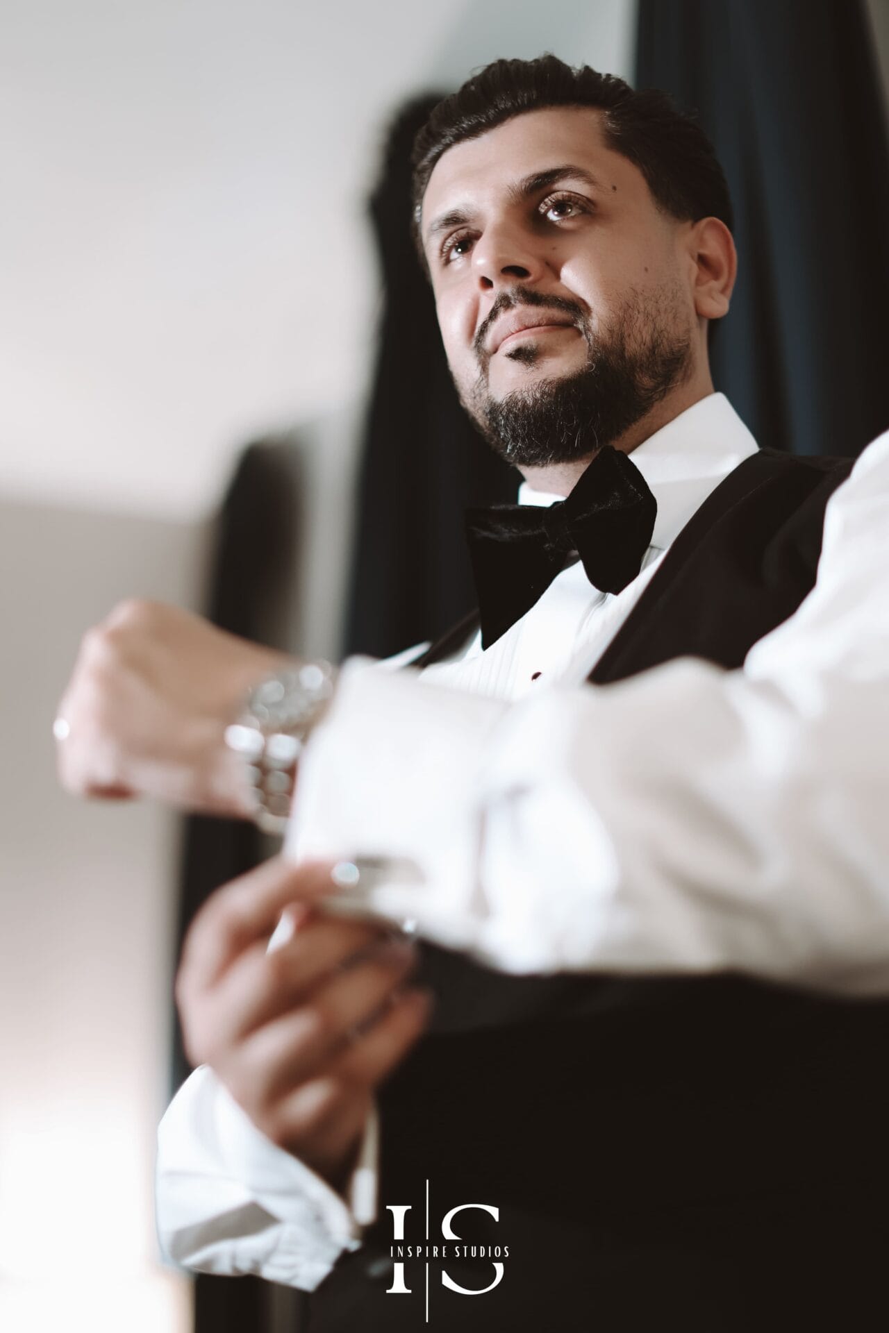 Groom getting ready portraits capturing suit details, cufflinks, watch, and relaxed wedding morning moments.